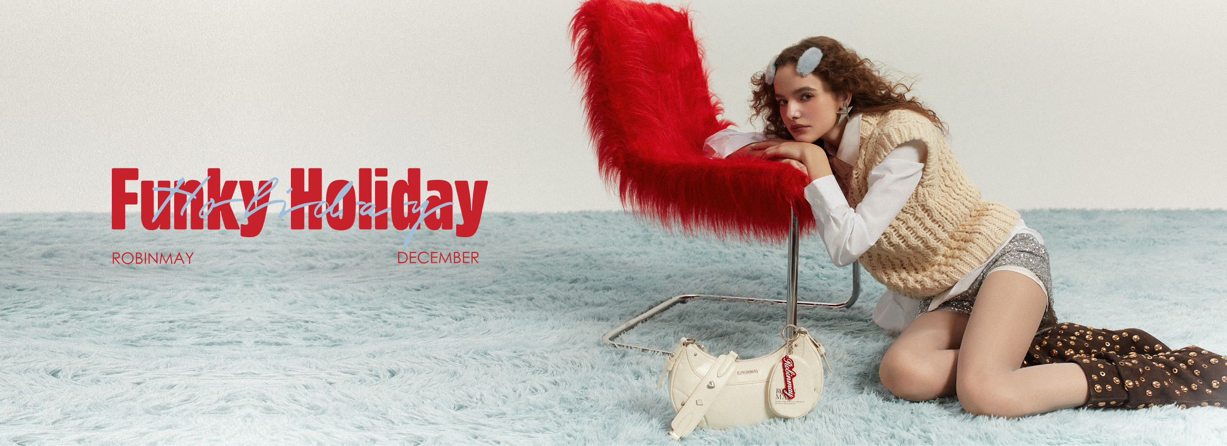 模特兒倚靠紅色毛感椅子，前面放置Crystal彎月肩背包