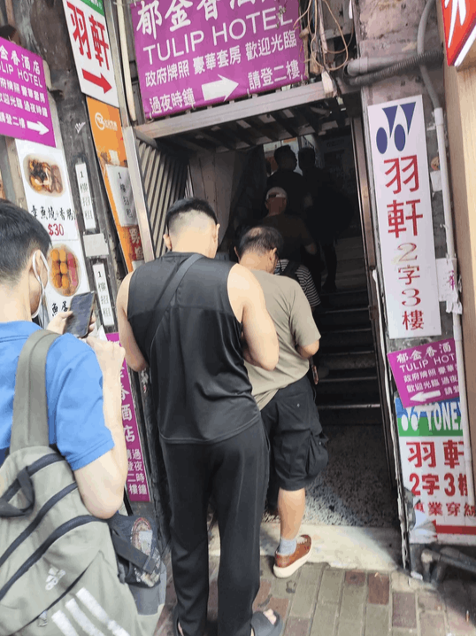 香港的建興大廈，很多男士低頭排隊，等待去召妓。