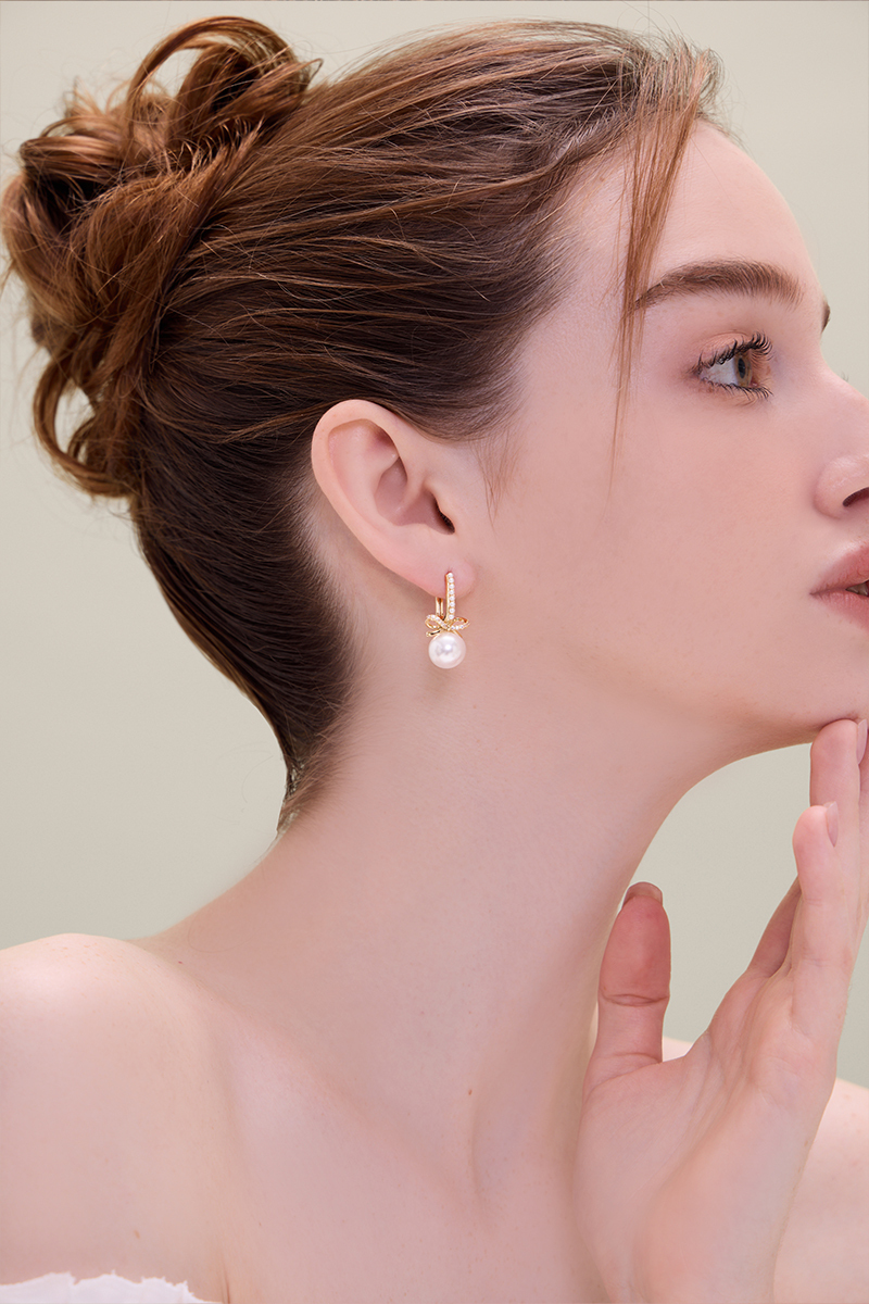 排列珍珠蝴蝶結。針式耳環