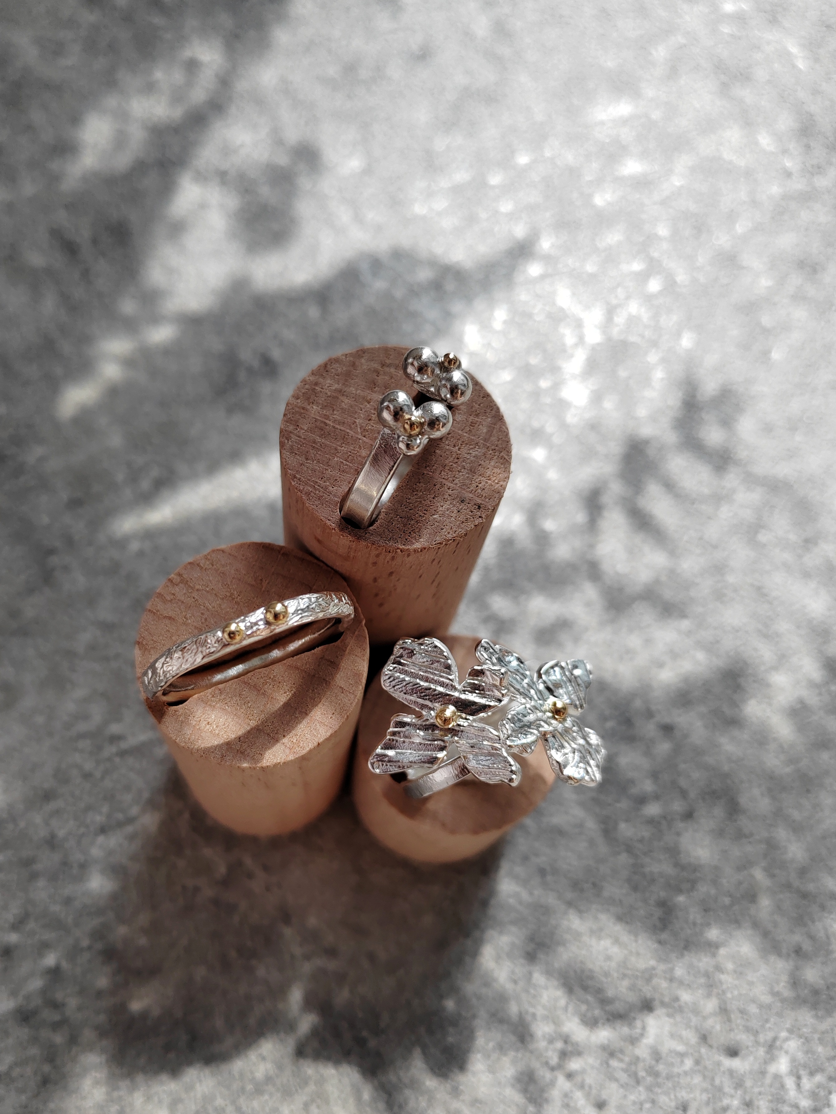 Elegant handcrafted silver and gold rings with unique textures and floral-inspired designs, perfect artisan keepsakes.