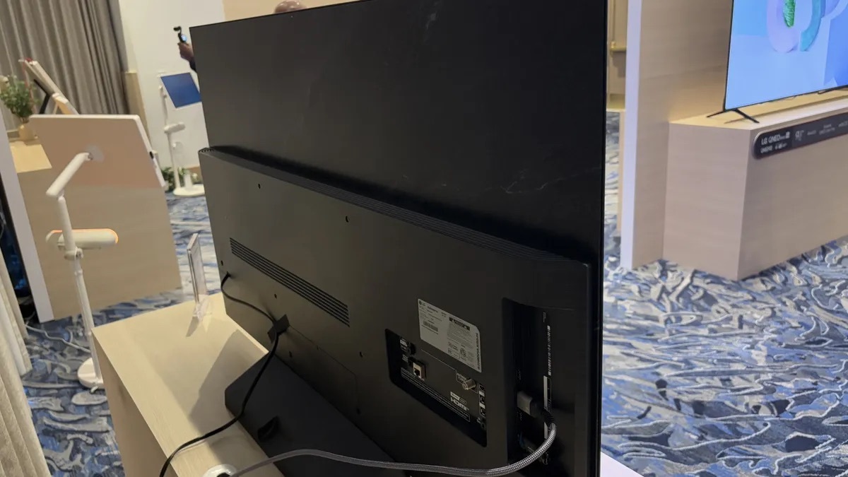 LG C5 OLED 智能電視的背面展示，顯示其連接埠和設計細節，包括電源線和其他連接介面。該電視擁有纖薄的背板設計，強調其現代感和簡約美學，非常適合用於高端室內裝飾環境。