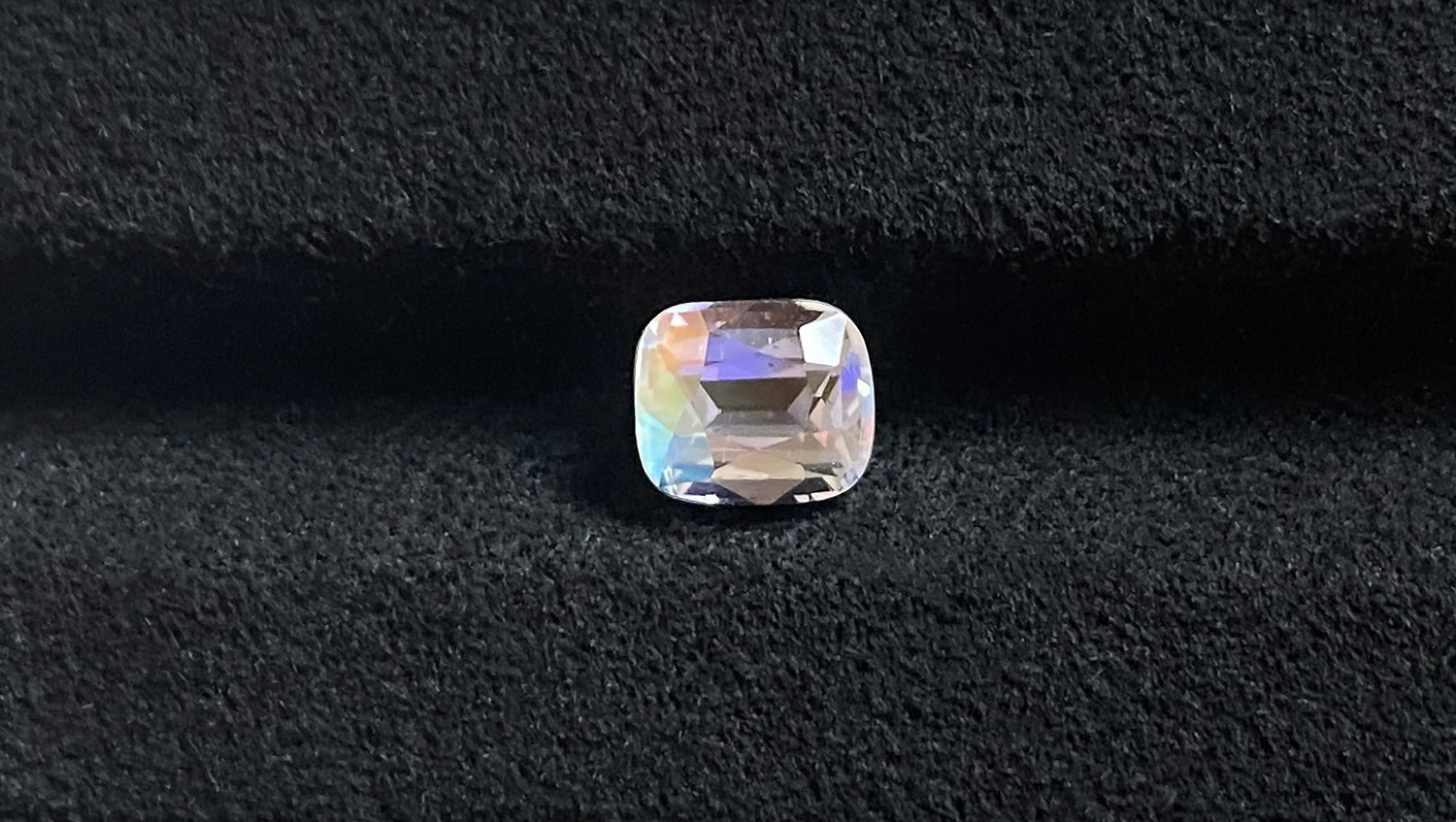 A 1.10 carat cushion cut of moonstone featuring an orange flash effect.