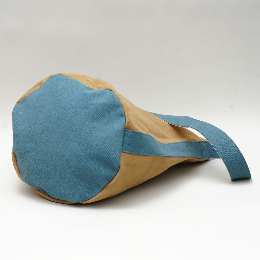 阿福圓筒帆布包正面展示，褐土色調與立體圓柱設計，適合日常與旅行使用