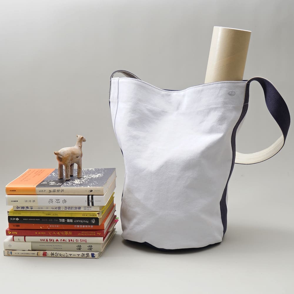 阿福圓筒帆布包正面展示，白色圓柱設計，適合日常與旅行使用