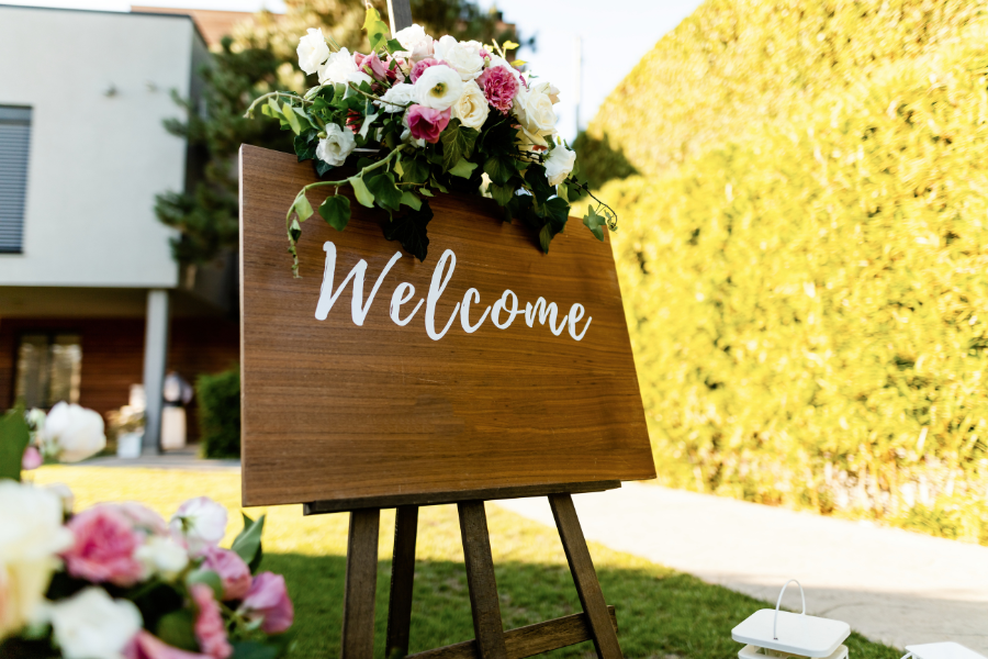 婚禮宴客場外放著歡迎賓客到來的木製立牌，上頭寫著”Welcome”