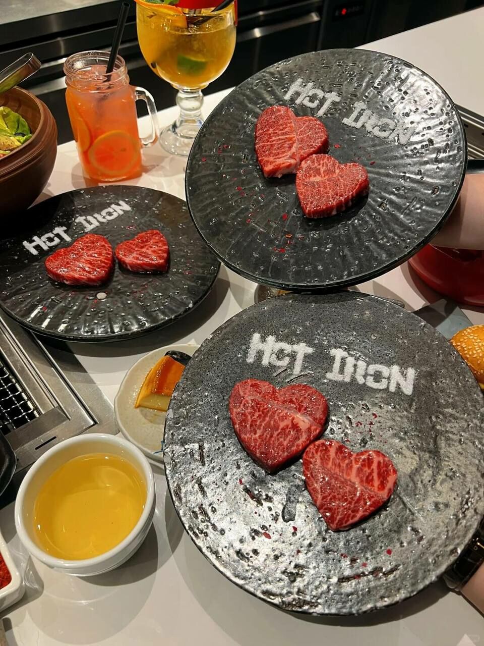 餐廳桌面上擺放著心型的高級牛肉盤和特色飲品,適合情人節約會用餐。