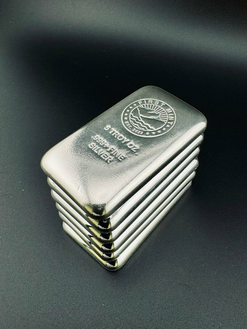 一疊五盎司純銀銀條，表面印有 FIRST MINT 標誌與 999% FINE SILVER 字樣，用於投資與貴金屬收藏