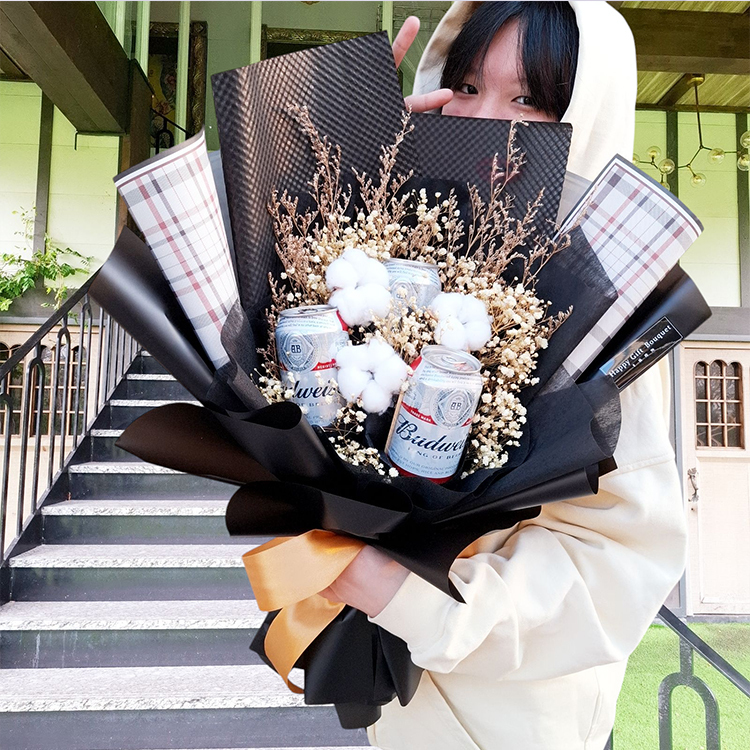 可愛女孩拿啤酒花束在樓梯前面,Cute girl holding a bouquet of beer in front of the stairs