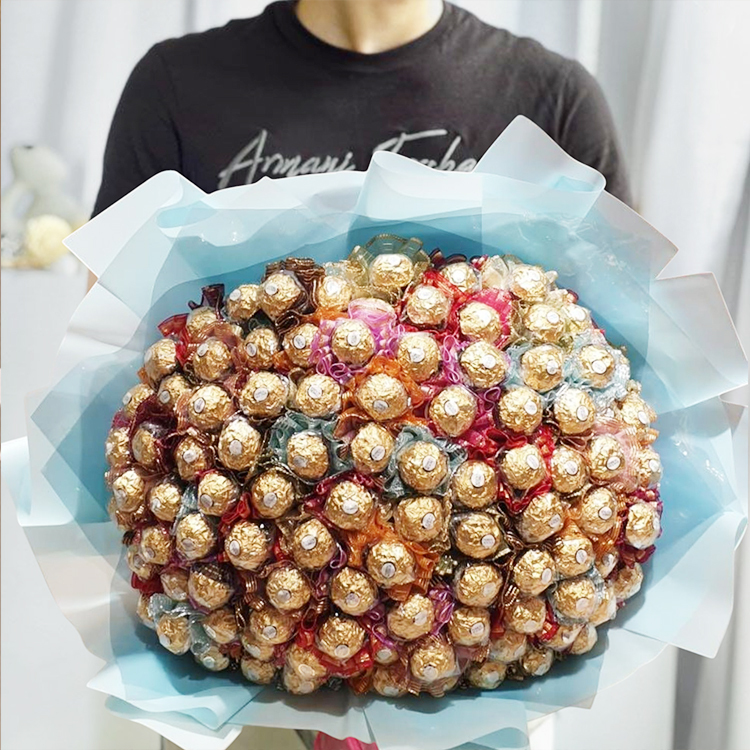 100支金莎花束,藍色包裝,男人川著黑色T恤拿著金莎花束,100 Ferrero Rocher bouquets, blue packaging, a man in a black T-shirt holding a Ferrero Rocher bouquet