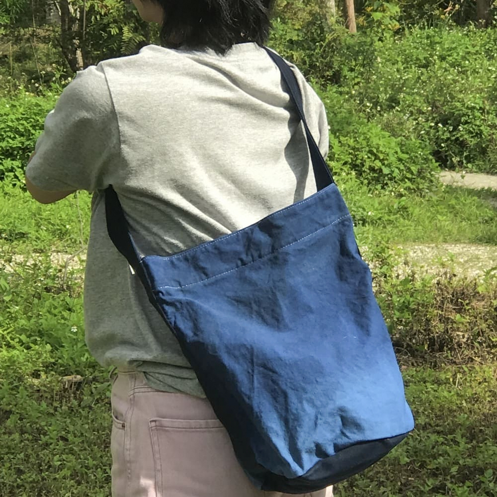 阿福圓筒帆布包正面展示，藍染漸層色彩自然過渡，圓筒形設計適合日常外出