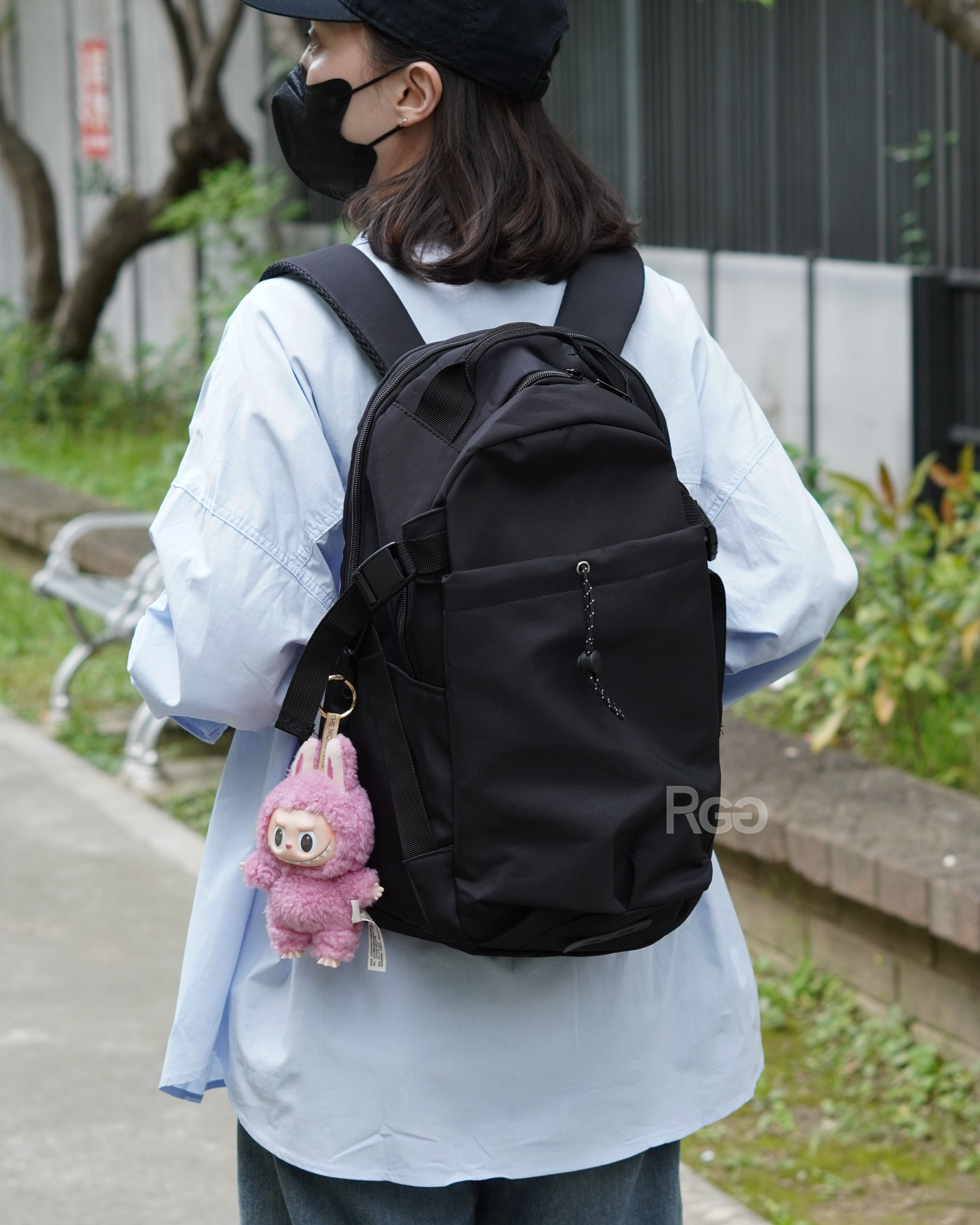 女模背著輕量機能束口夾層後背包黑色半身照