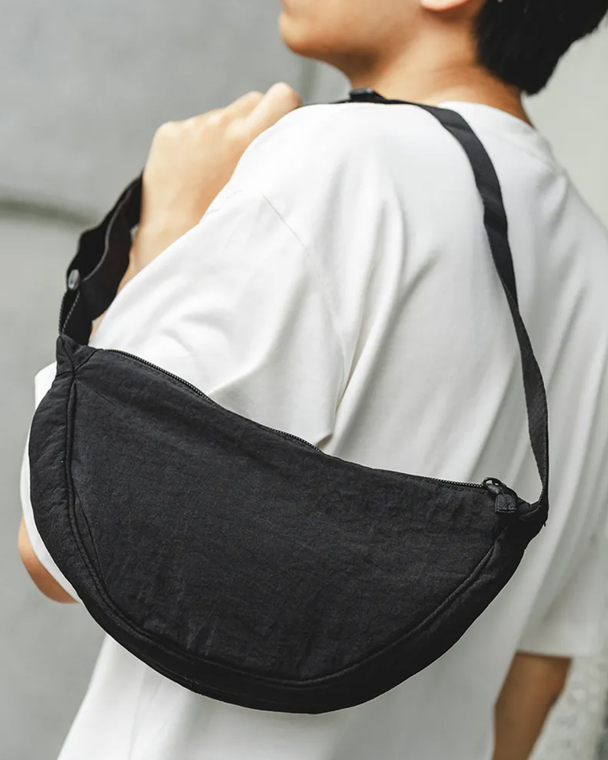 男模著尼龍半月型側背包黑色