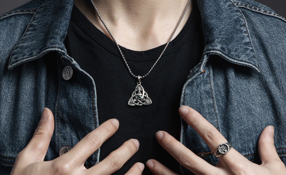 三態‧聖樹純銀吊墜 The Trinity States - Sacred Tree Silver Pendant，凱爾特三位一體結結構搭配中央綠寶石，展現靈魂三態與宇宙記憶象徵，圖為黑T與牛仔外套搭配穿戴示範，傳遞靜謐而堅定的靈性氣質