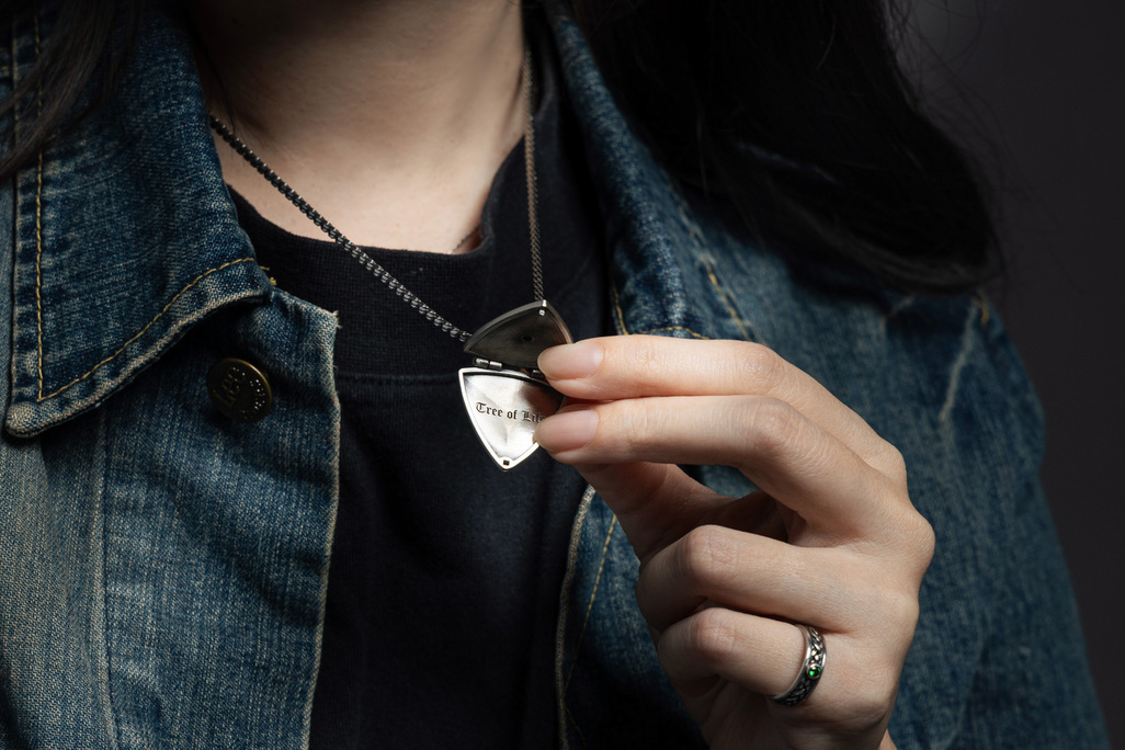 聖靈樹盾 開合純銀吊墜 Guardian Tree Shield Silver Locket，盾牌造型吊墜打開後可見內部刻有 Tree of Life 字樣，象徵靈魂守護與自我覺醒，圖為日常穿搭中的開合展示細節，展現飾品內在寓意與質感工藝
