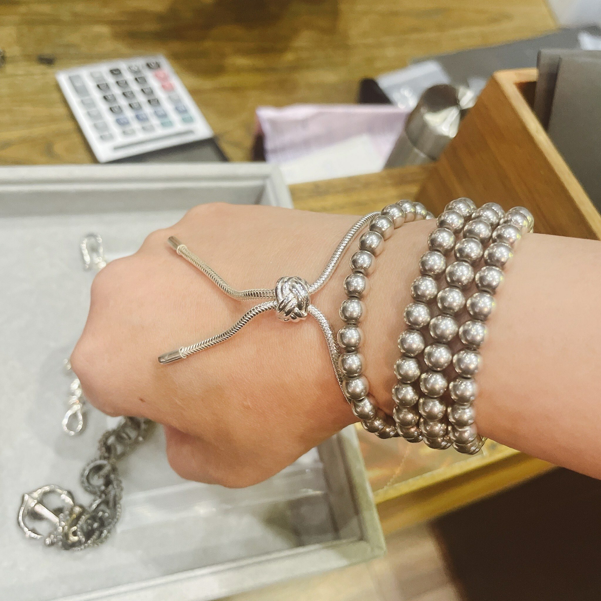 Silversmith香港銀飾品牌,顧客手上配戴多層925純銀珠手鍊與滑結繩結手鍊,展現簡約中帶有設計感的日常穿搭