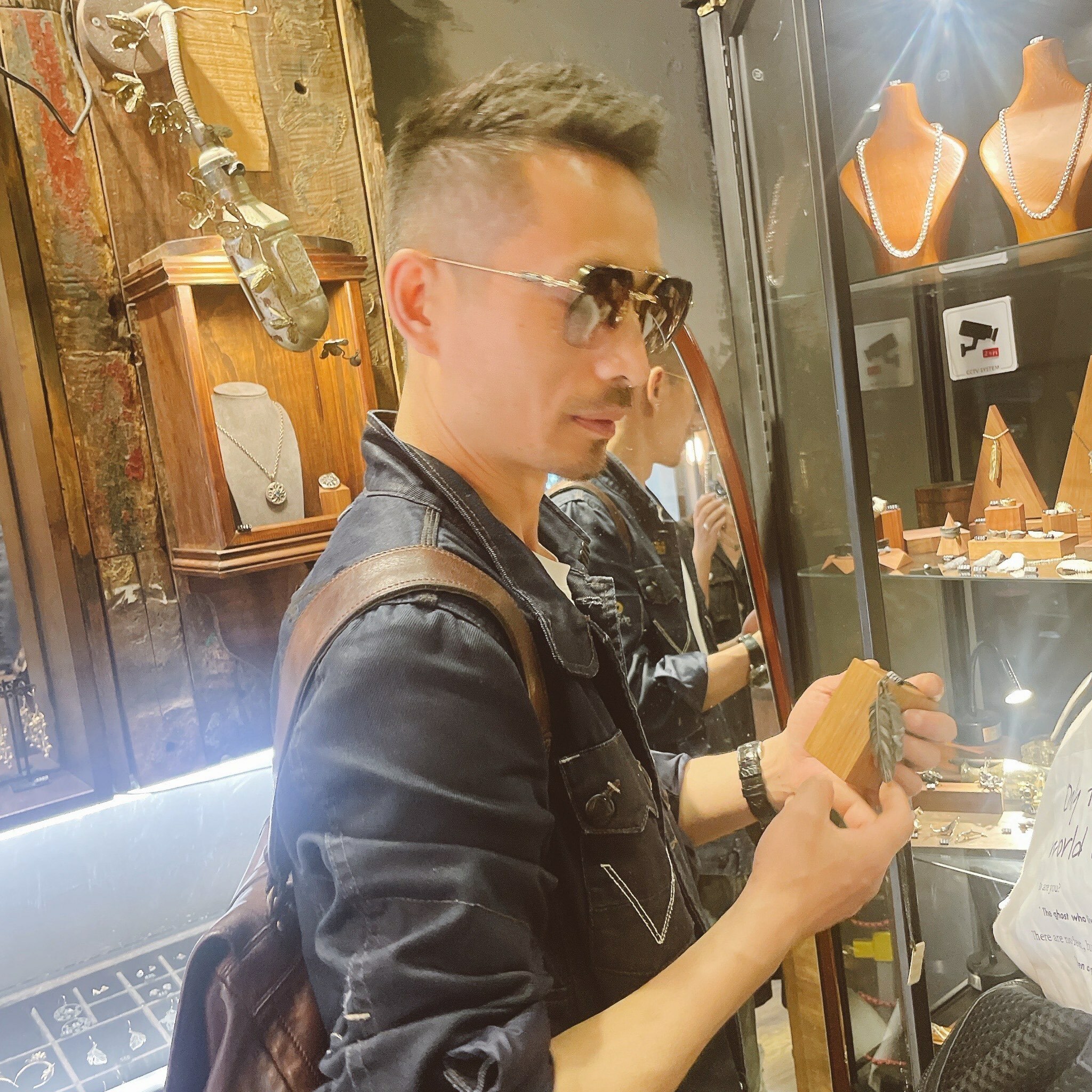 顧客於香港Silversmith銀飾店內挑選手工純銀飾品,展示櫃中擺放多款項鍊與戒指,店內充滿復古工藝氛圍