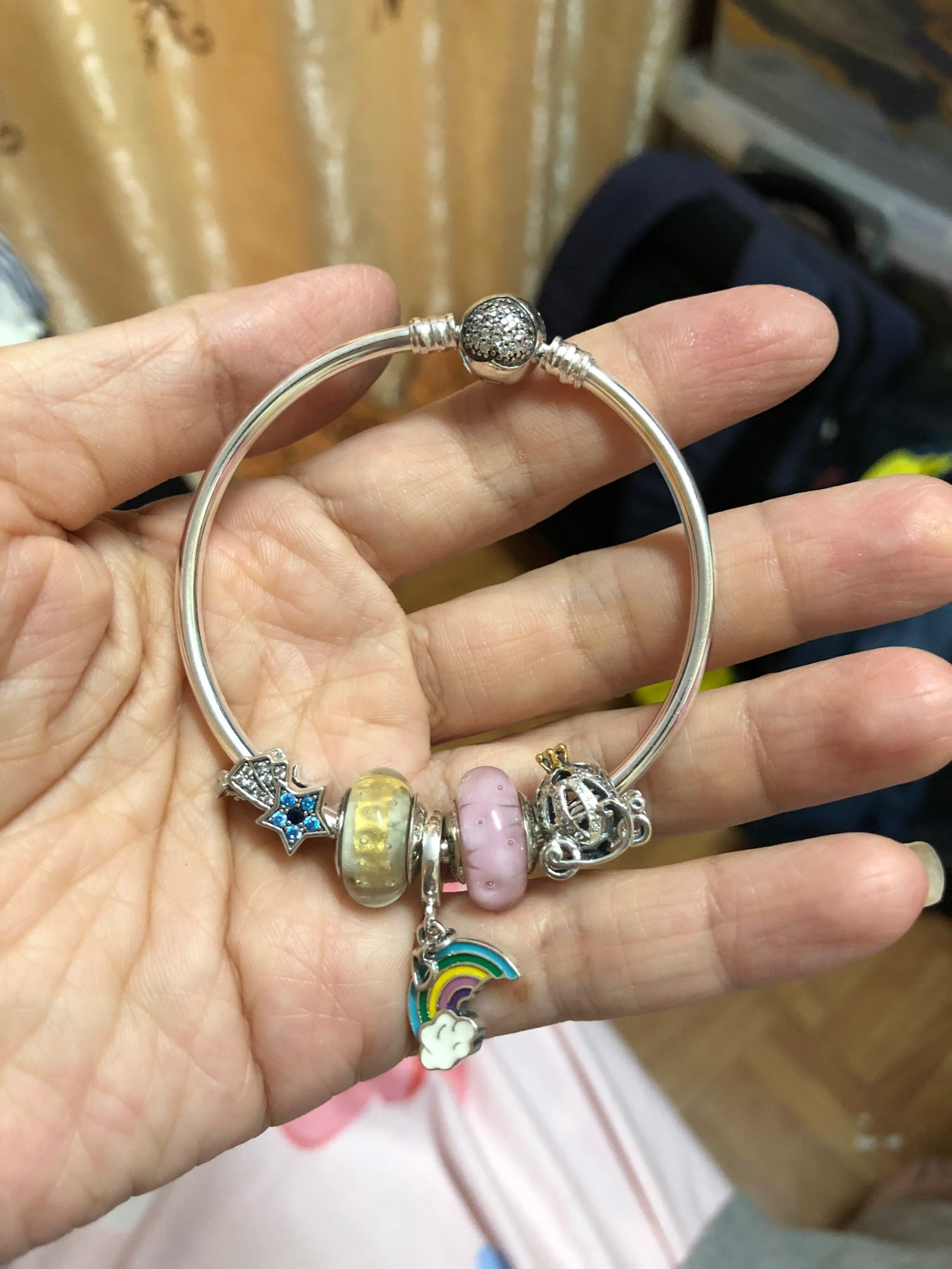 手持正生銀飾串珠手鐲,包含彩虹吊飾、皇冠珠、星星造型純銀珠