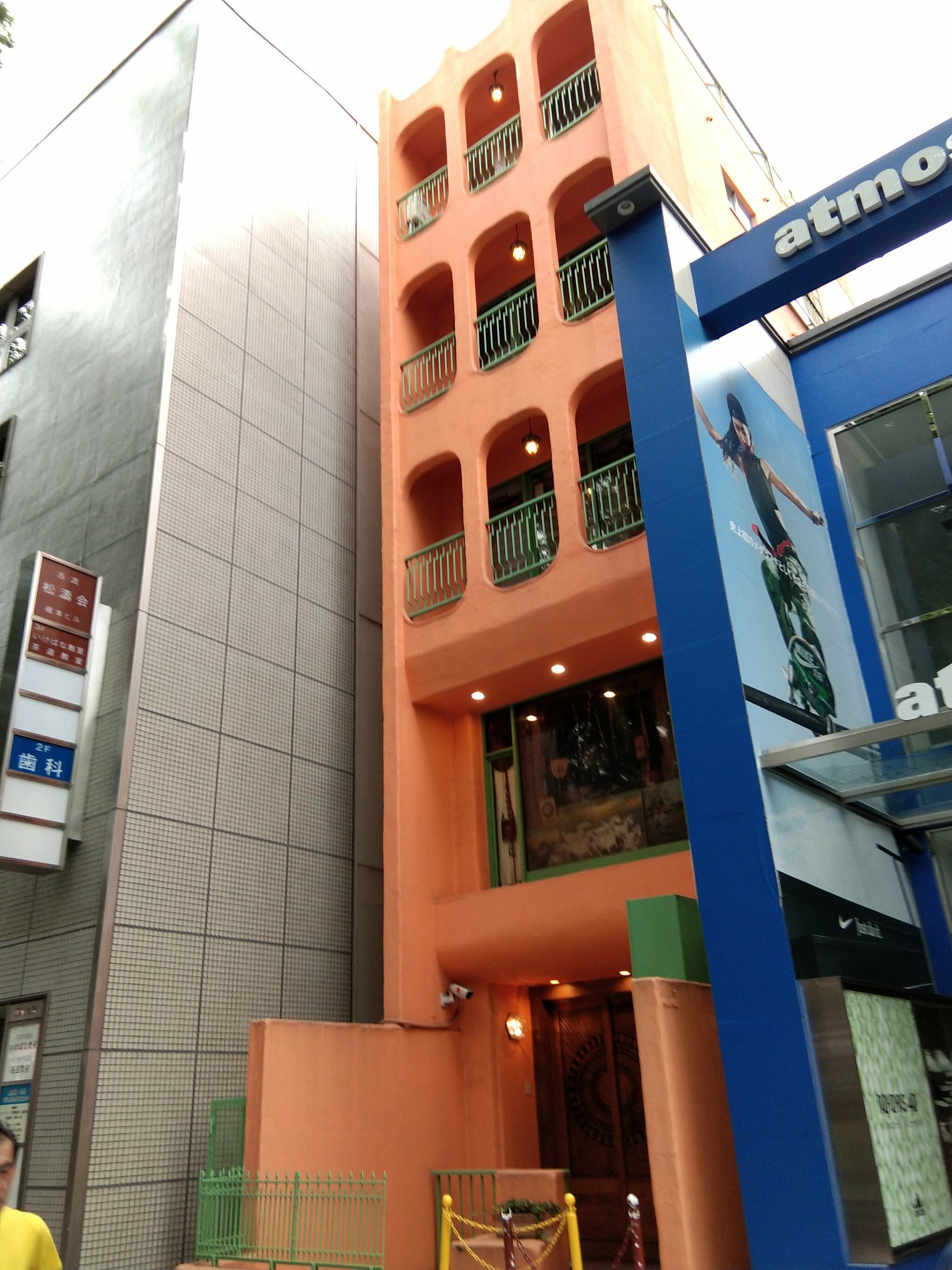 Goro's東京表參道門市建築外觀,橘色牆面設計搭配綠色欄杆,位於atmos旁