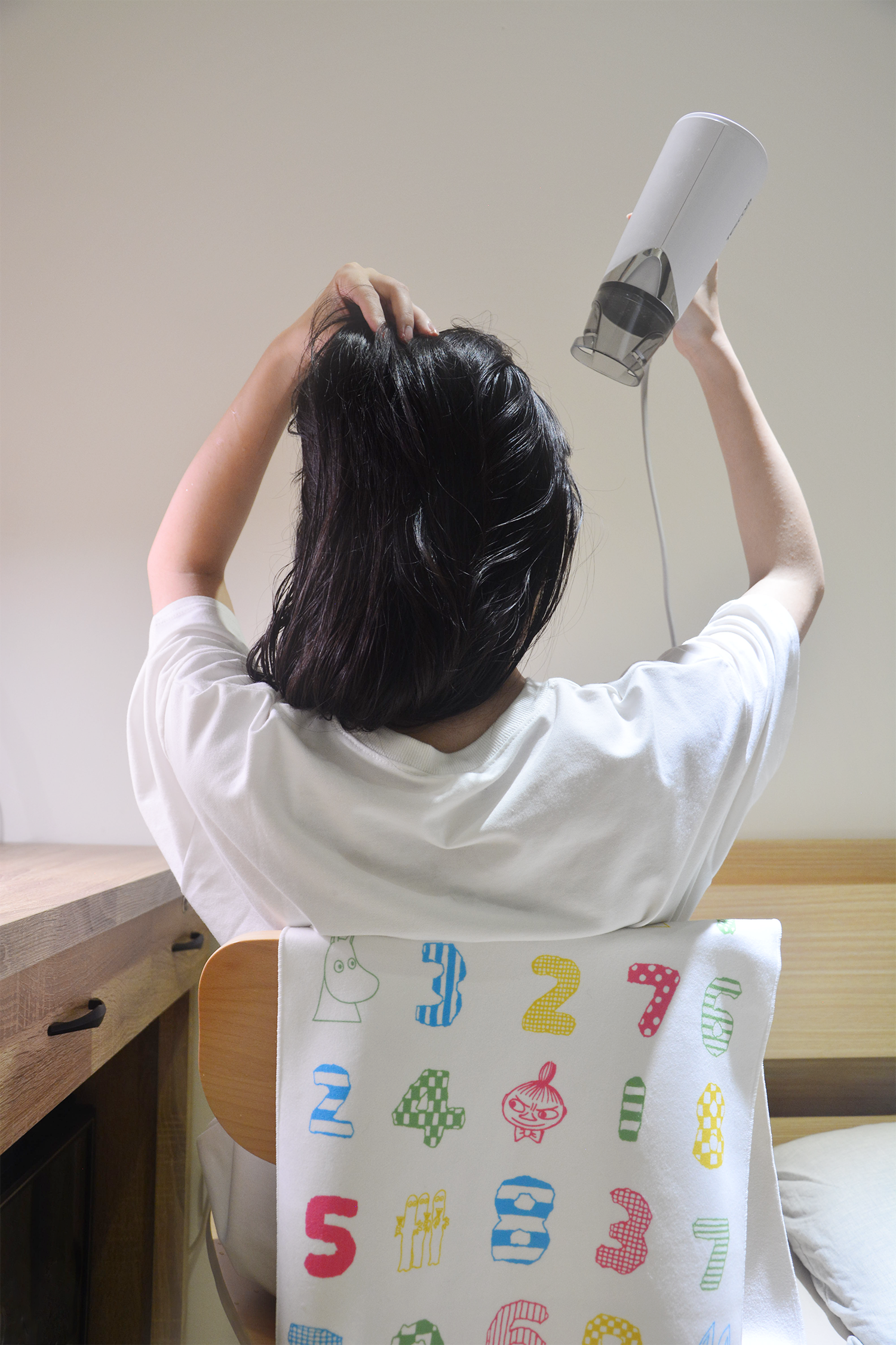 女孩在椅子上披著Moomin嚕嚕米 x SOU・SOU擦髮巾吹頭髮