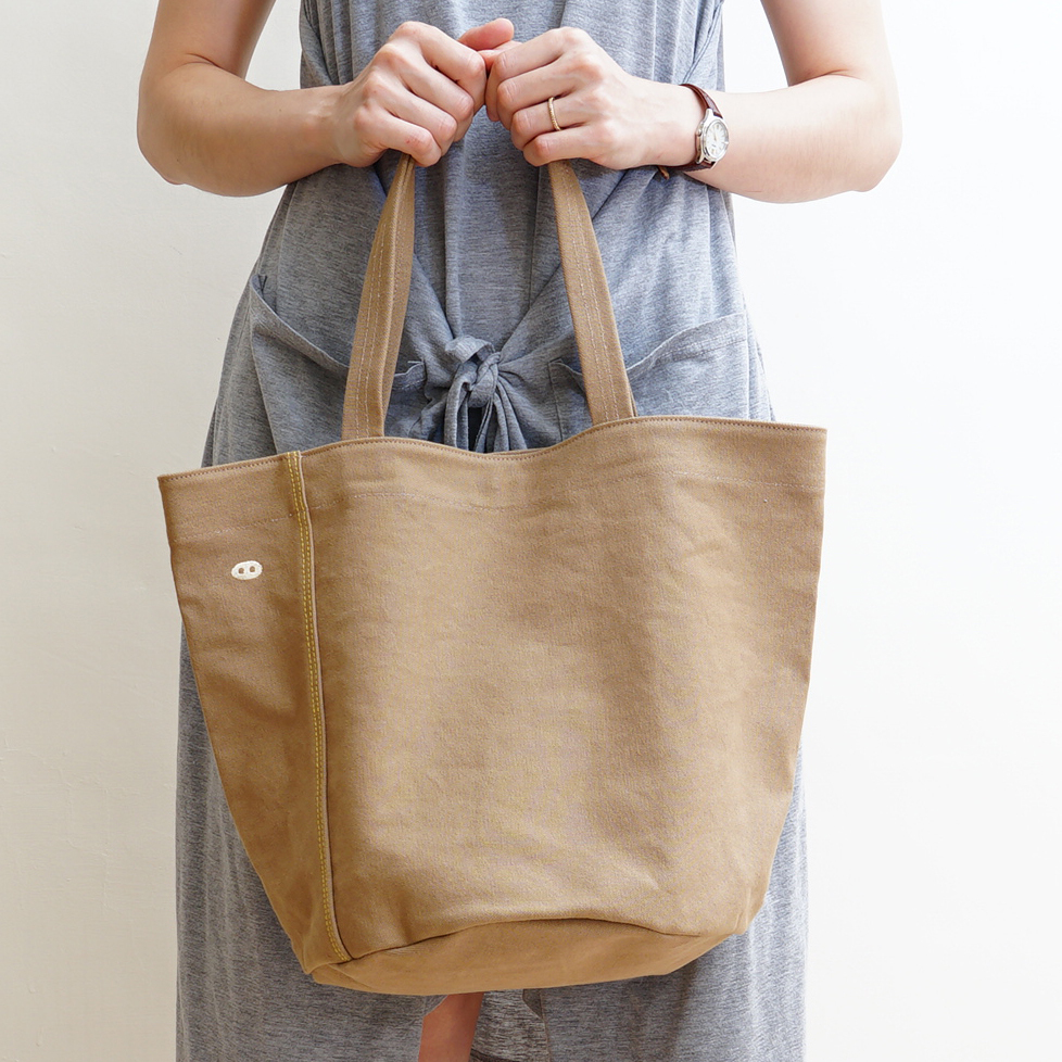 帆布托特包內部展示，附內袋與淺色裡布，小尺寸設計可容納隨身用品