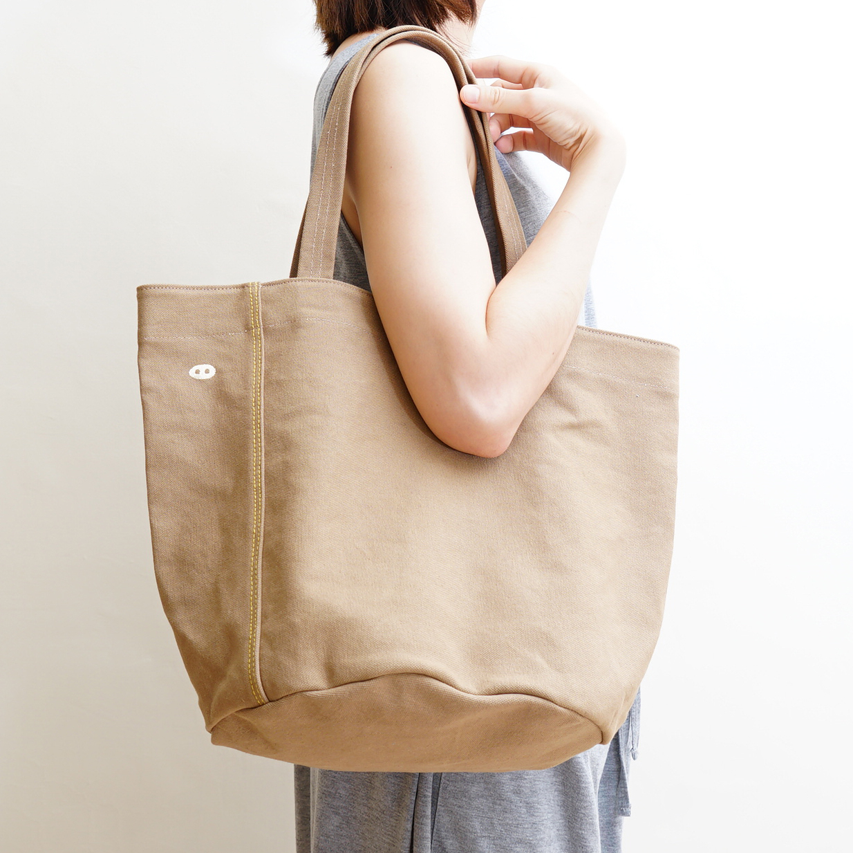 小Cam 帆布托特包背面俐落設計，無外口袋，呈現自然布料紋理