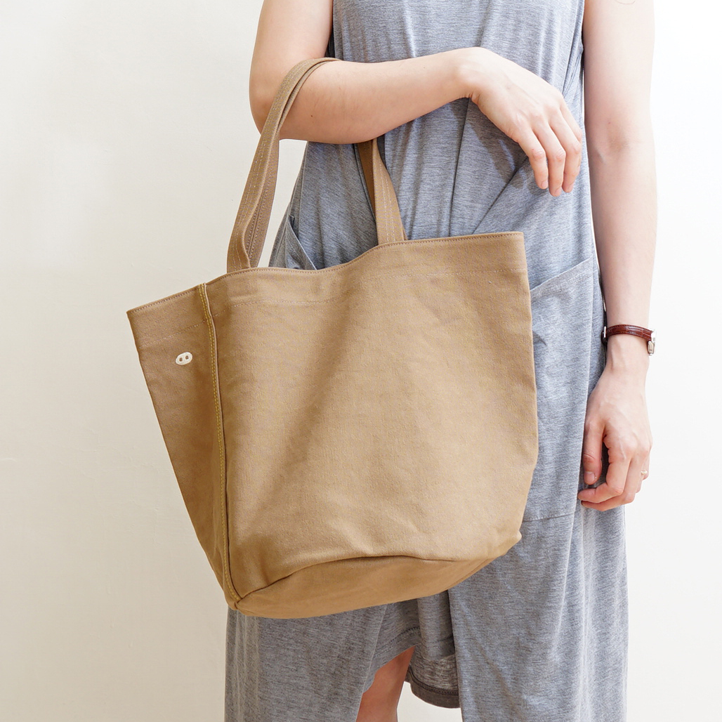 帆布托特包內部展示，附內袋與淺色裡布，小尺寸設計可容納隨身用品