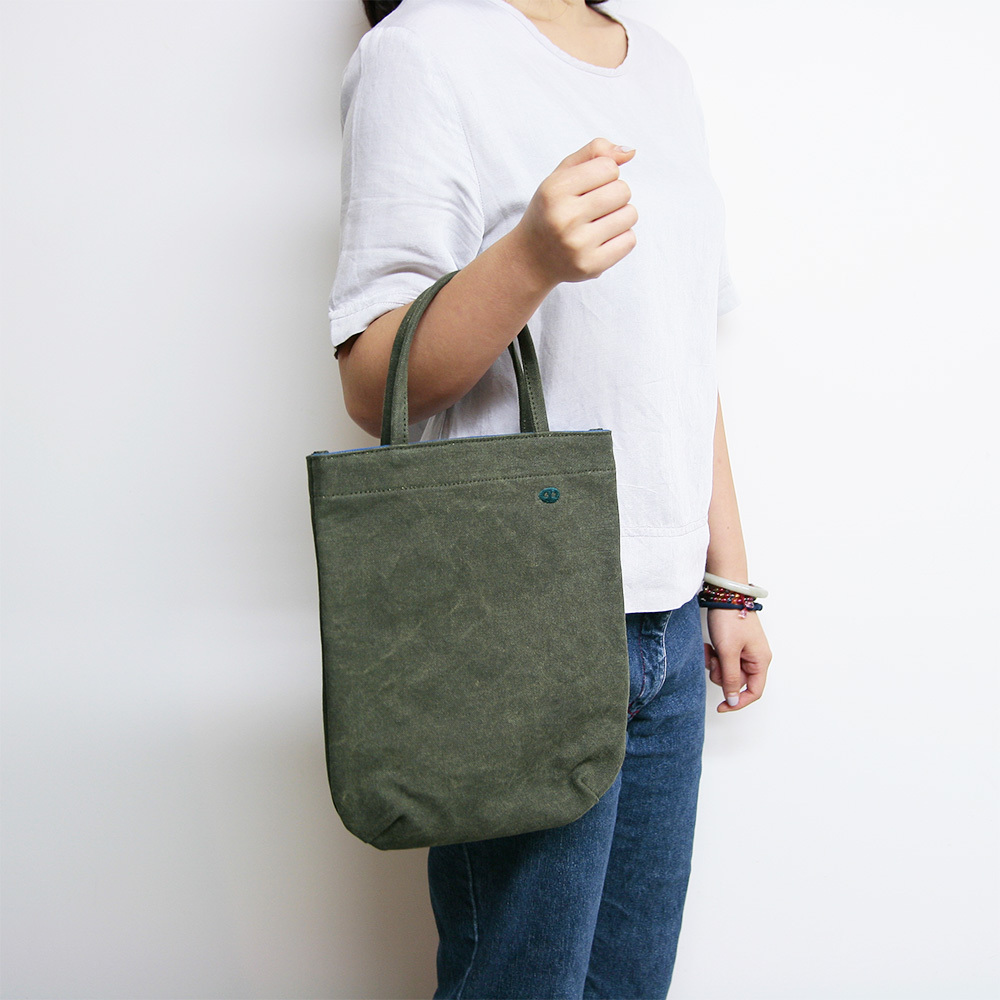 甘單小包軍綠帆布手提包正面展示，小巧圓弧剪裁，適合日常外出使用