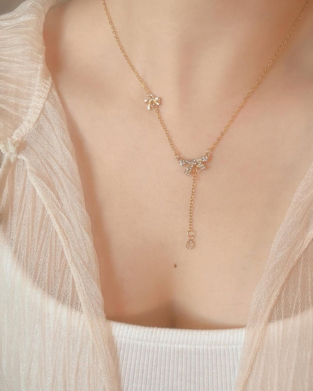 鑲鑽的蝴蝶結,像陽光灑落的碎金,輪流閃閃發光🌟 下方垂墜的線,像是在心裡的思念那樣綿長 讓視覺拉長,偷偷地修飾脖子與臉型🦢 上方有個小巧思 加了一個素面的小蝴蝶結🎀 有別於一般只有一個吊墜的設計 讓整體造型更加特別、更加精緻 是會被漂亮死的一條項鍊😳🤍 搭配春夏的小裙子 已經能想到會有多好看!!!