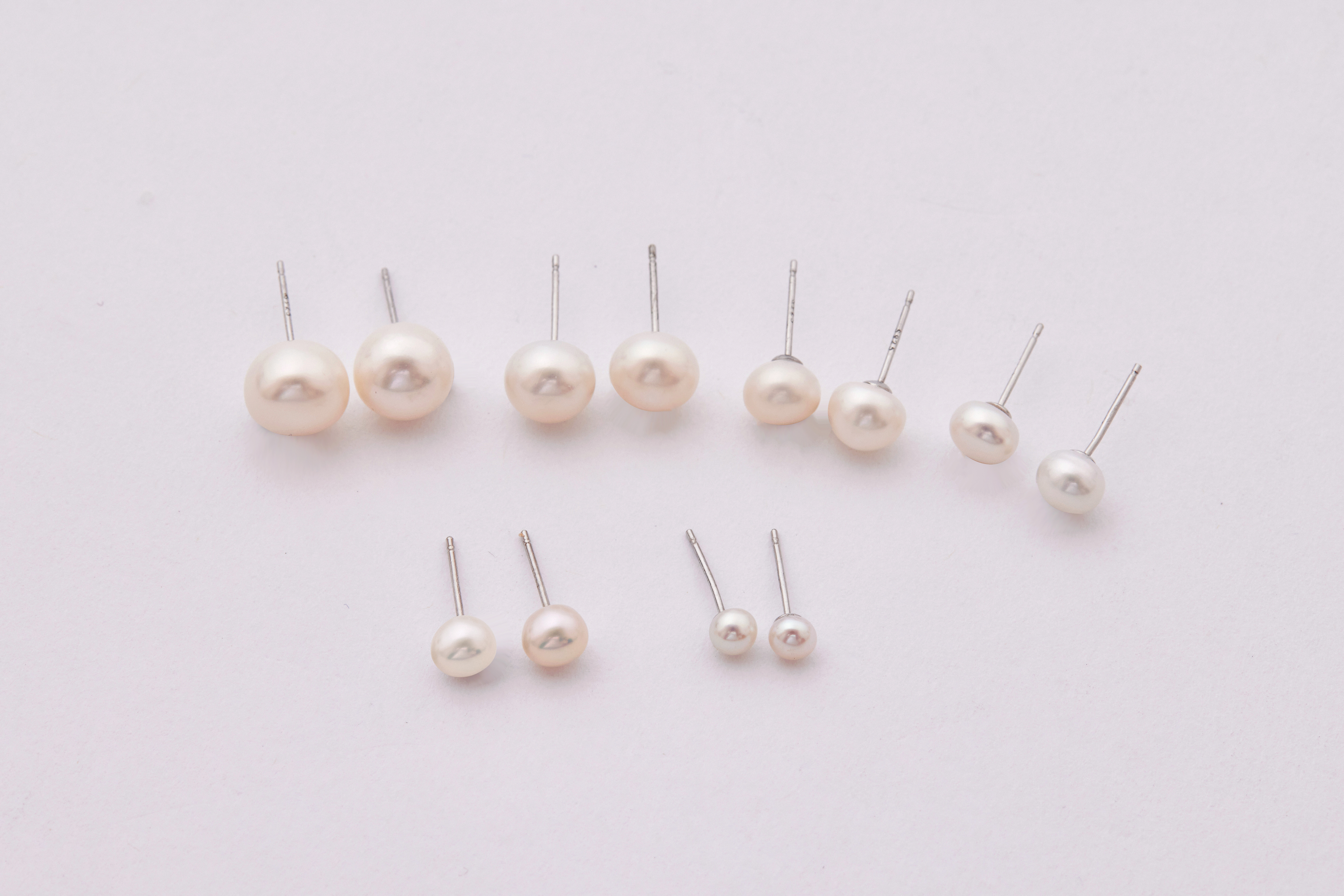 不同尺寸的白色珍珠並排展示，展現珍珠大小差異