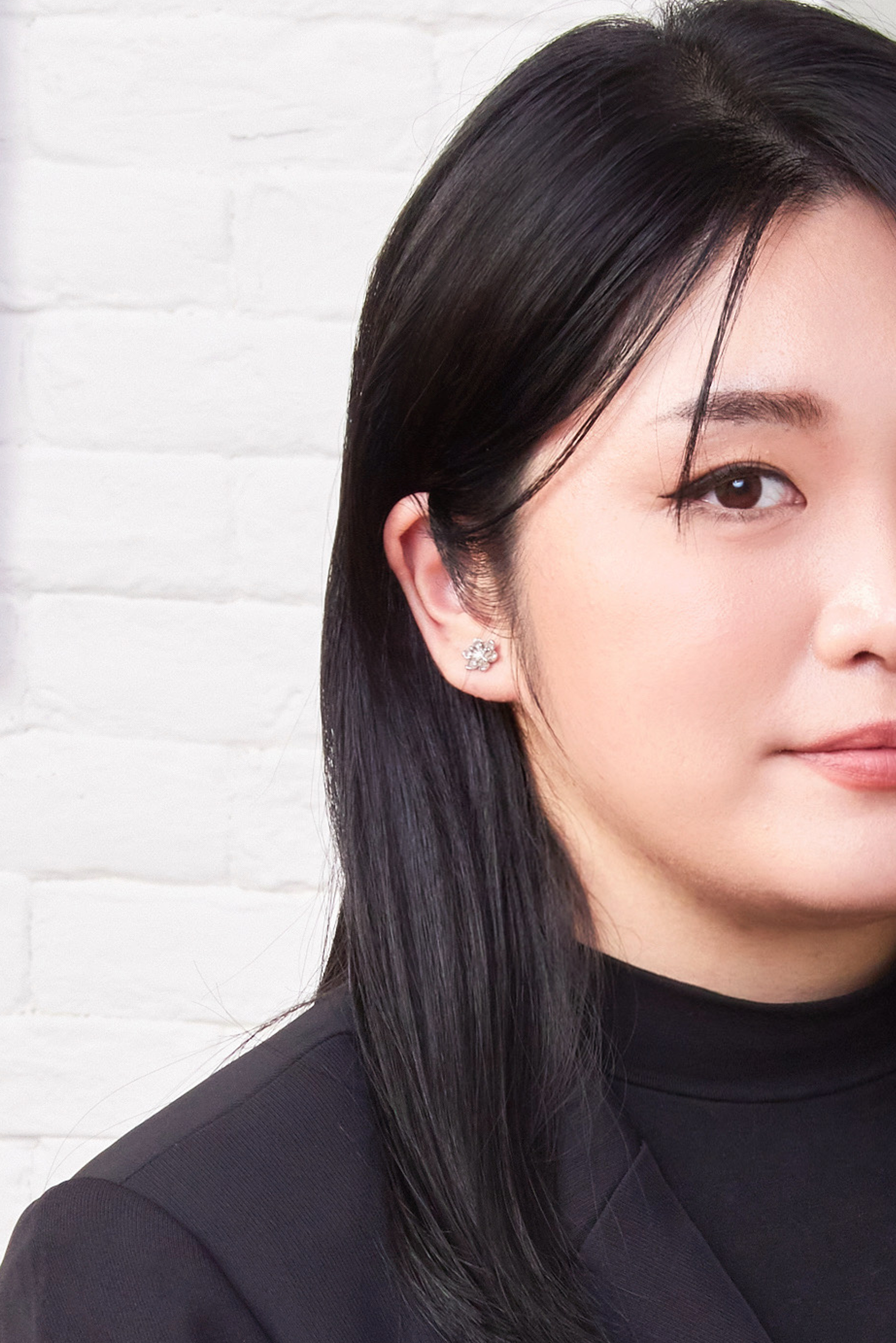模特半臉構圖佩戴純銀花朵耳環，耳際細節清晰，呈現自然氣質與光澤