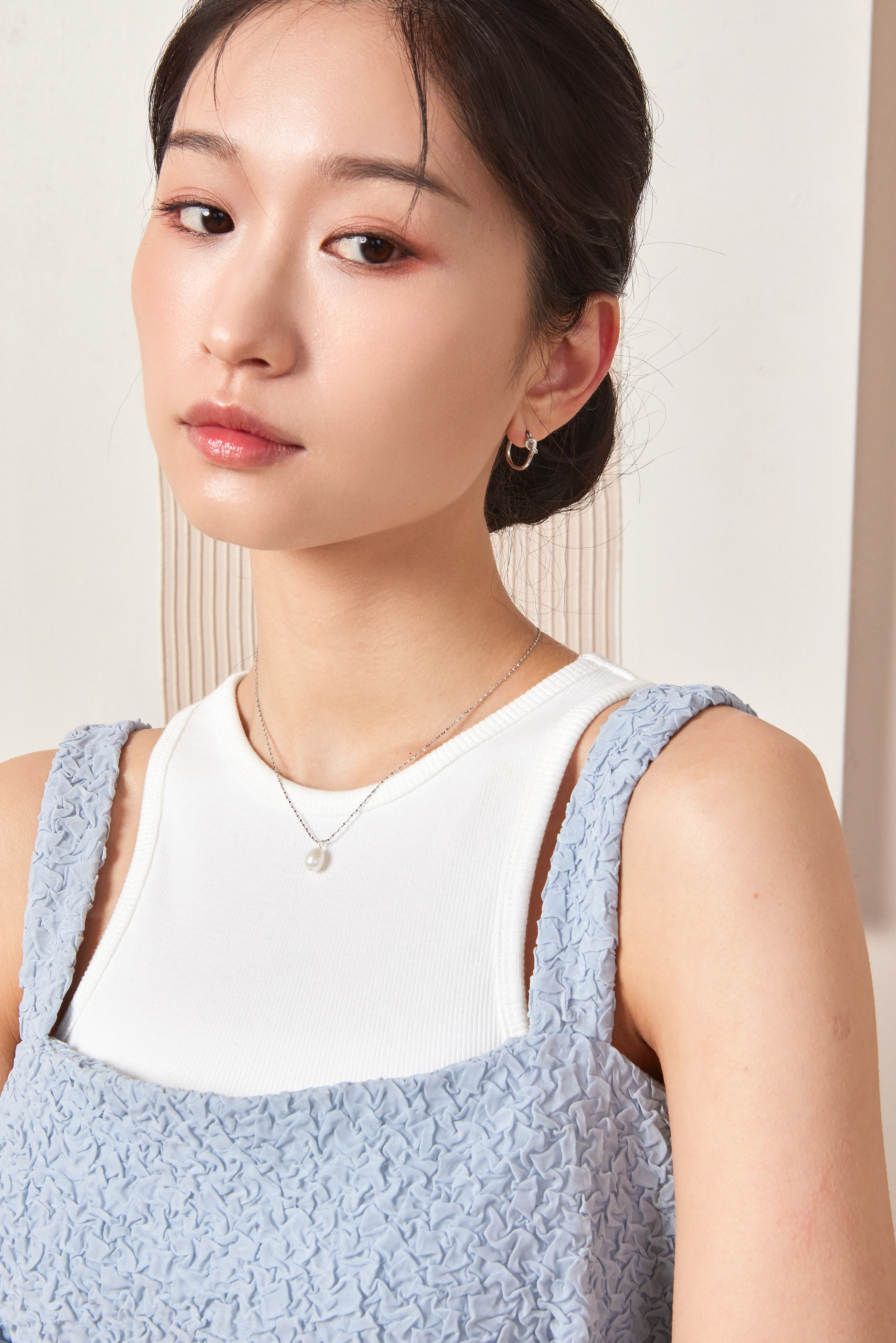 模特佩戴純銀紐結耳環的正面穿搭照，展現俐落優雅氣質