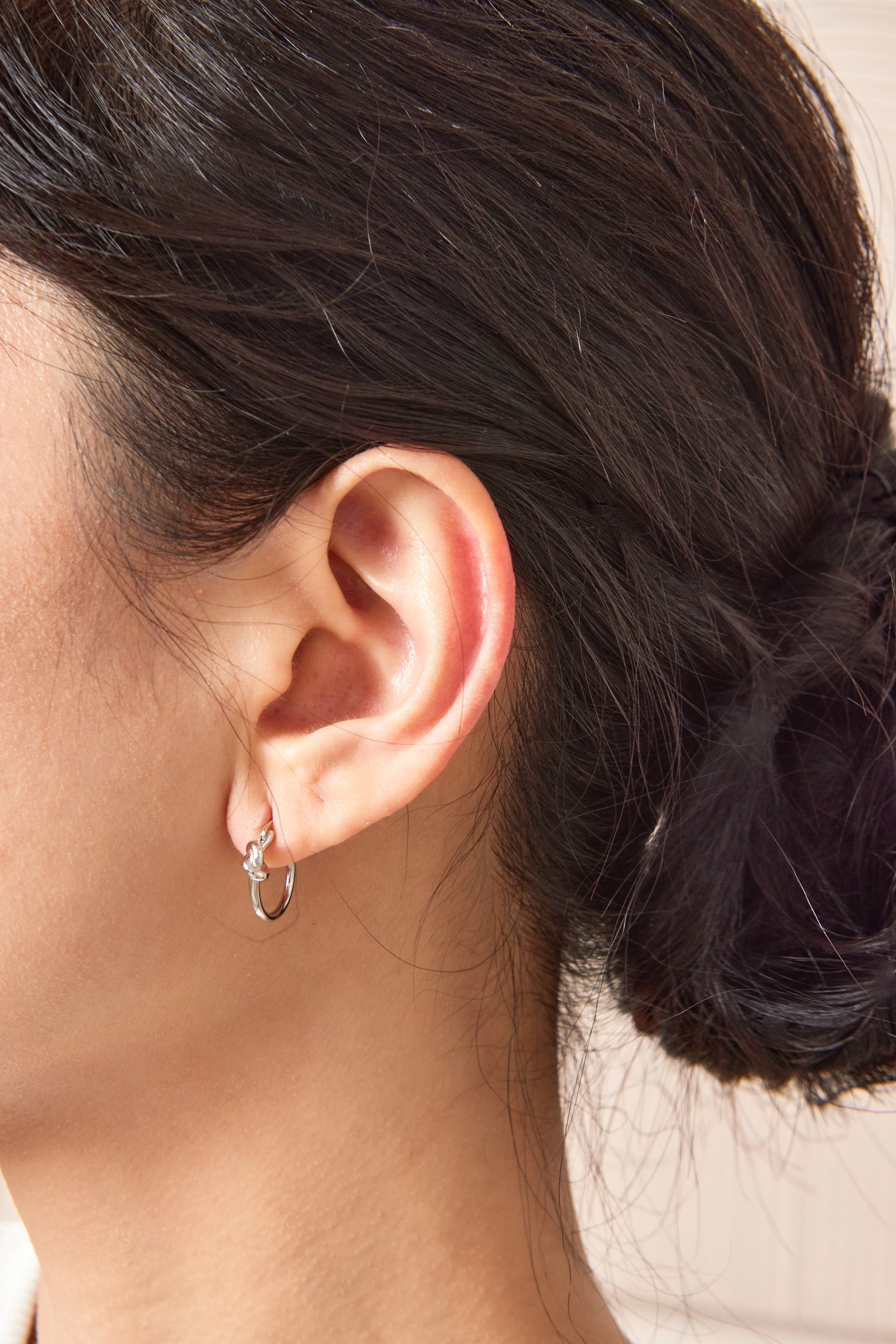 模特露出紐結耳環的特寫照，呈現簡約與個性兼具的設計感