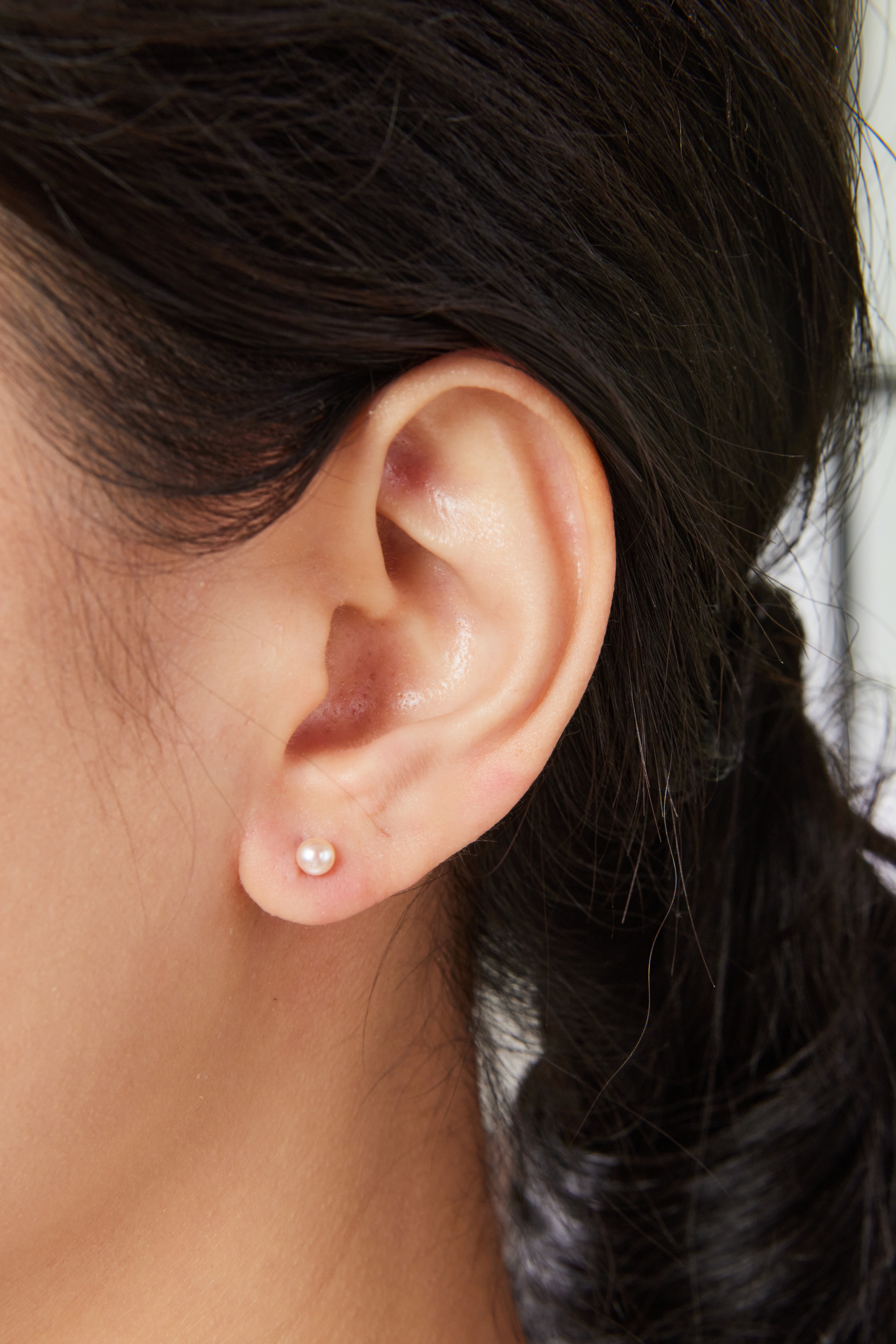 模特配戴 4–4.5mm 橘粉珍珠耳環，細緻自然，輕盈不搶戲