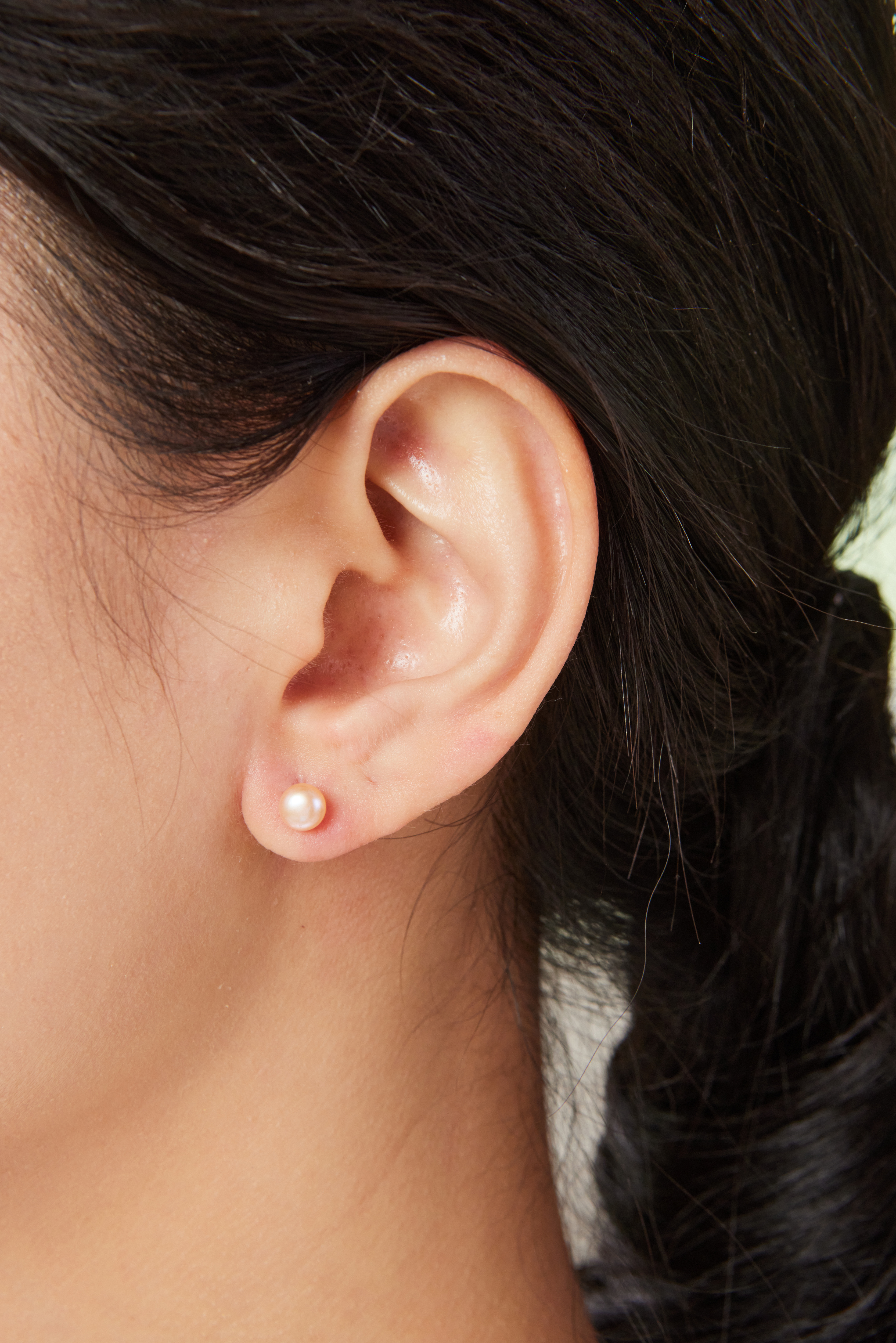 模特配戴 5–5.5mm 橘粉色珍珠耳環，溫柔感提升日常氣質