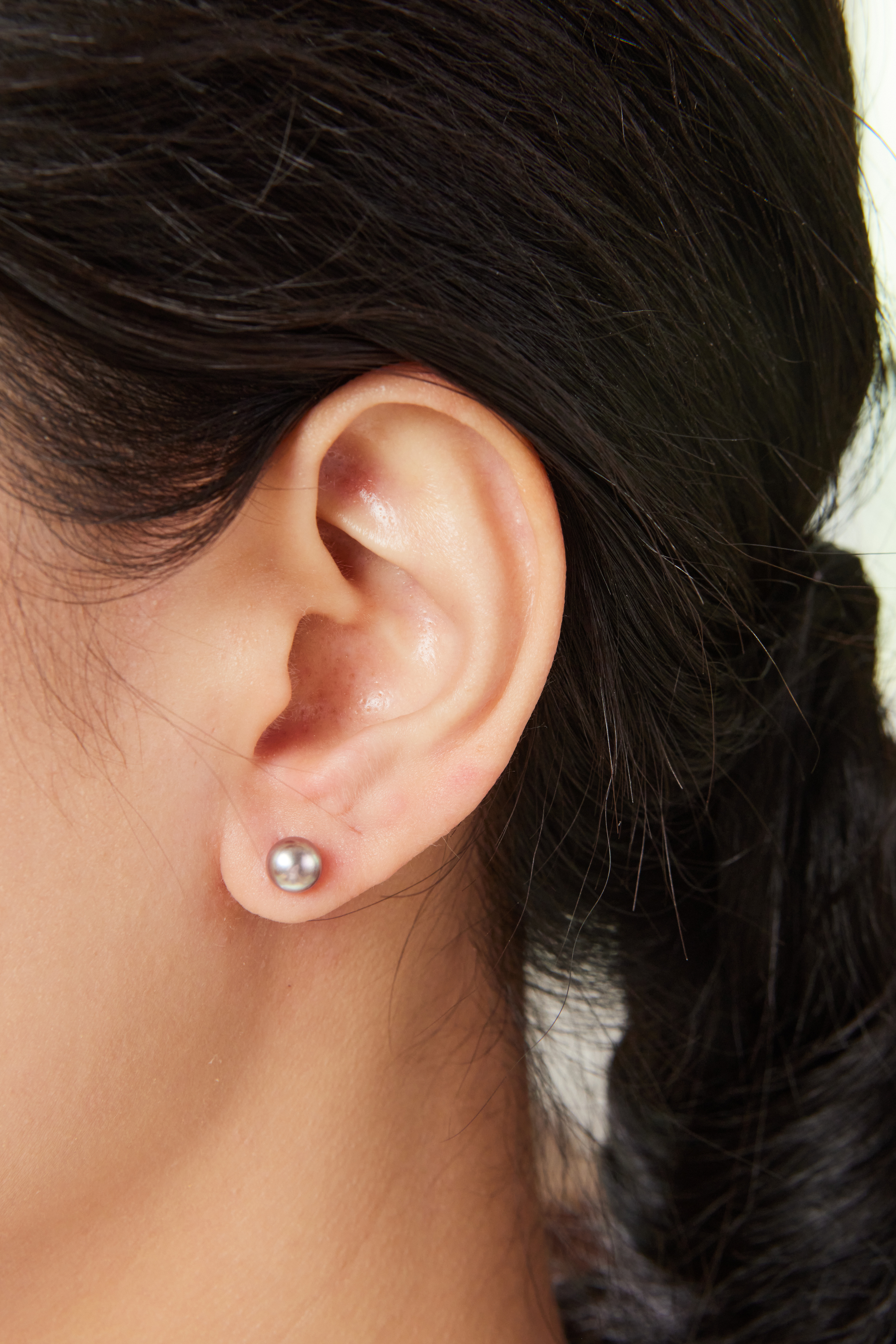 模特佩戴 6–6.5mm 灰紫珍珠耳環，尺寸適中，映出臉部光澤感