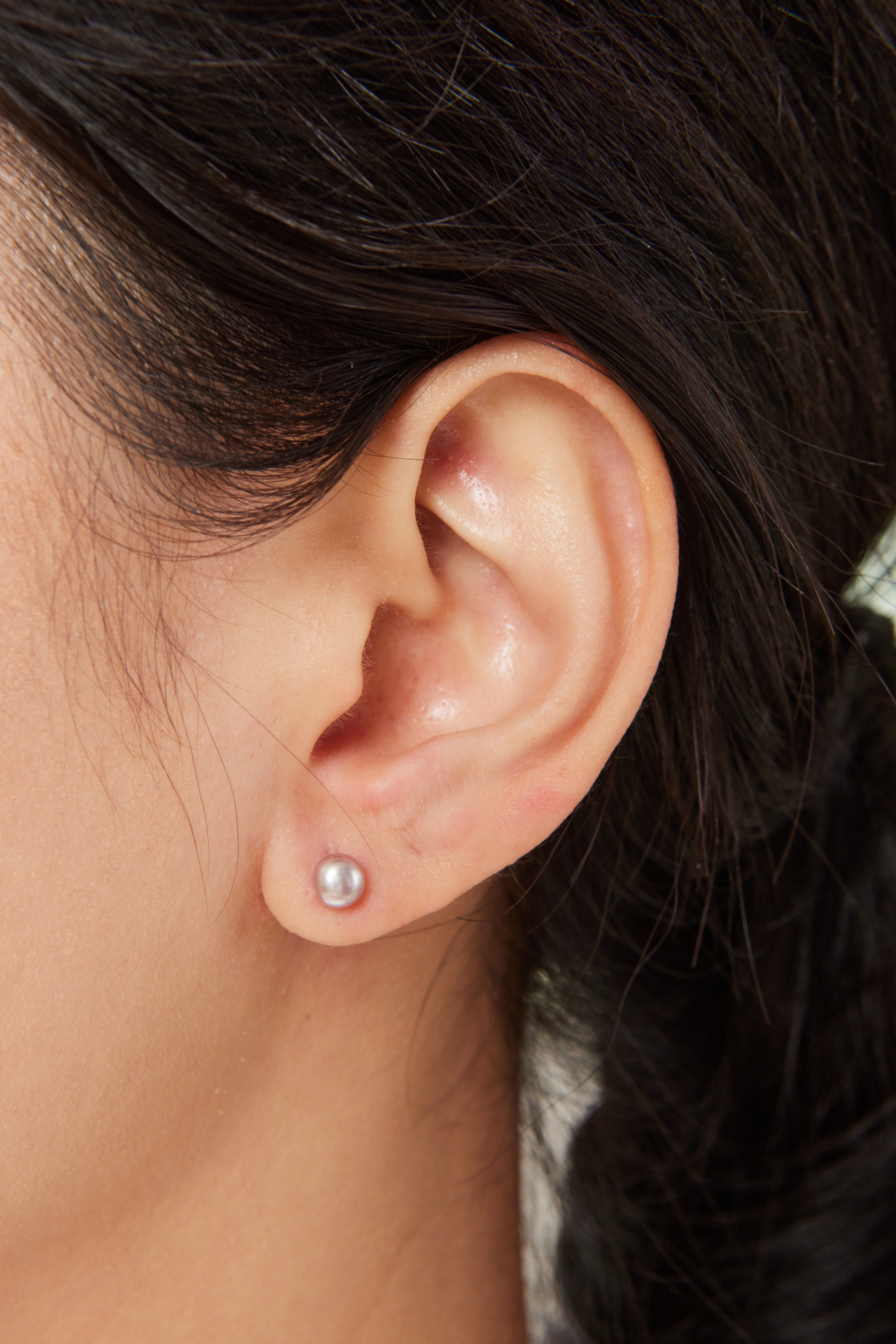 模特配戴 5–5.5mm 灰紫色淡水珍珠耳環，柔光中透出優雅氣息