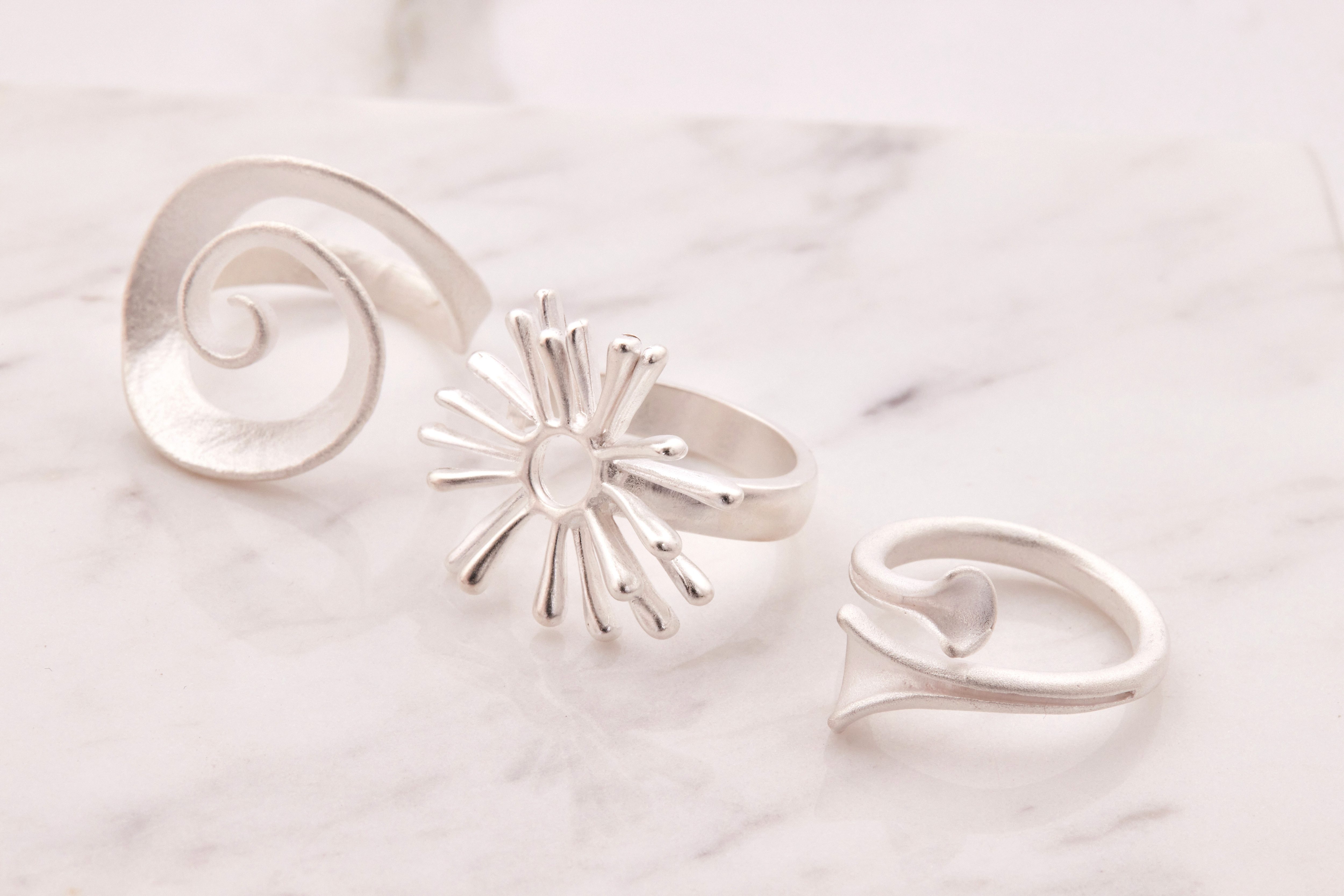 太陽花造型戒指近拍圖，線條與圓潤戒身設計