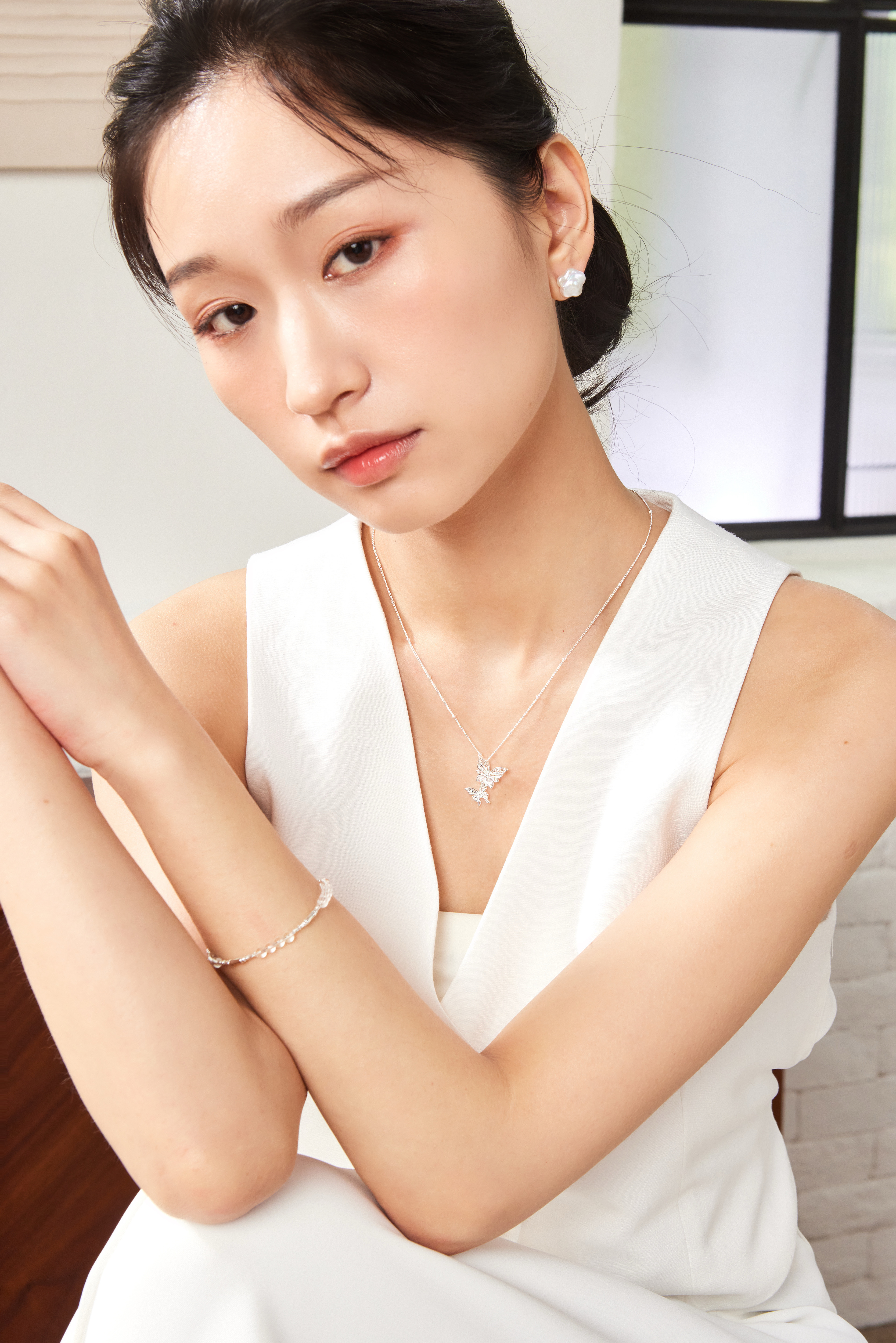 模特佩戴雙蝴蝶項鍊正面照，吊墜輕盈落於鎖骨之間