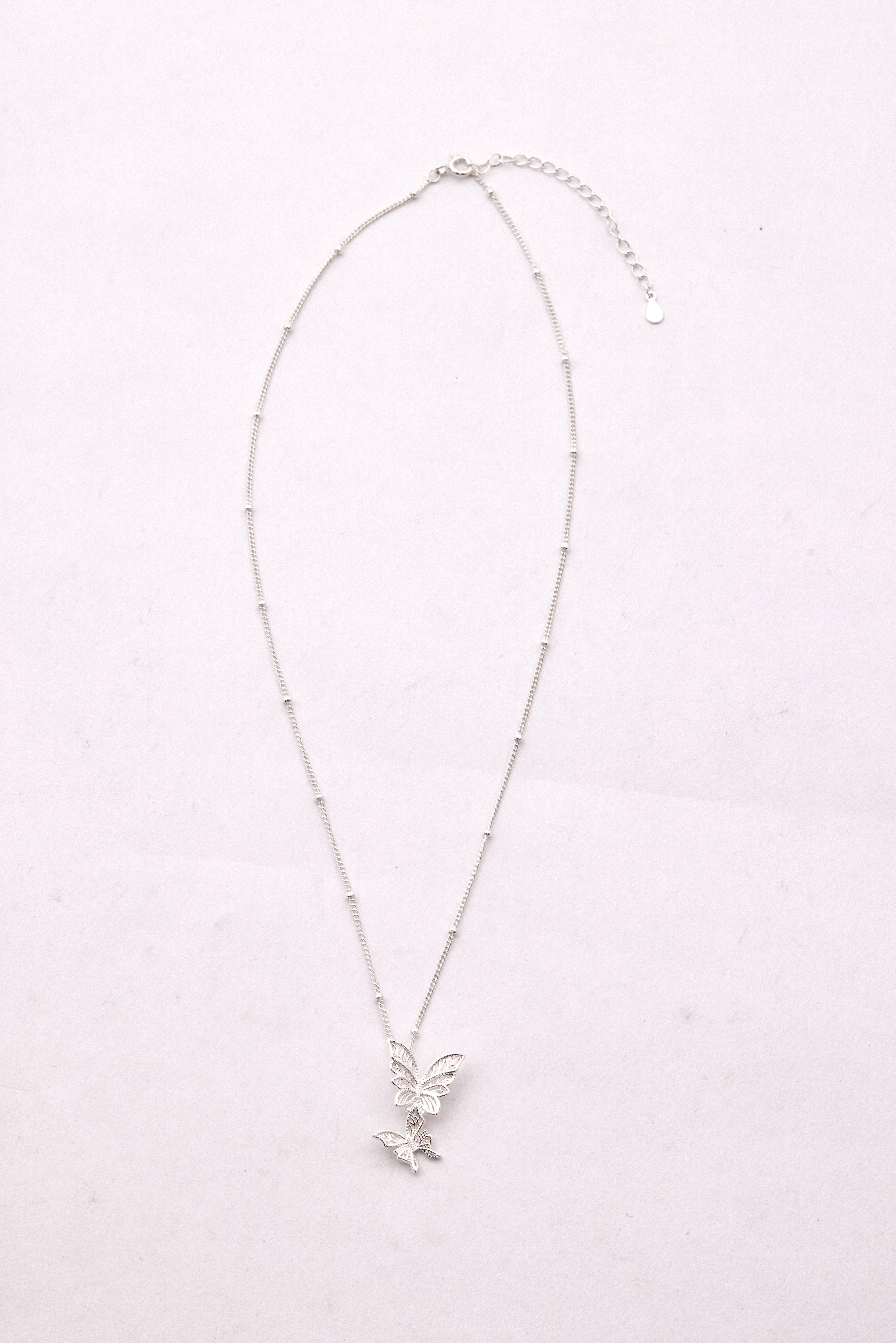 純銀項鍊平放構圖，展現鍊身與吊墜之間的比例與細節