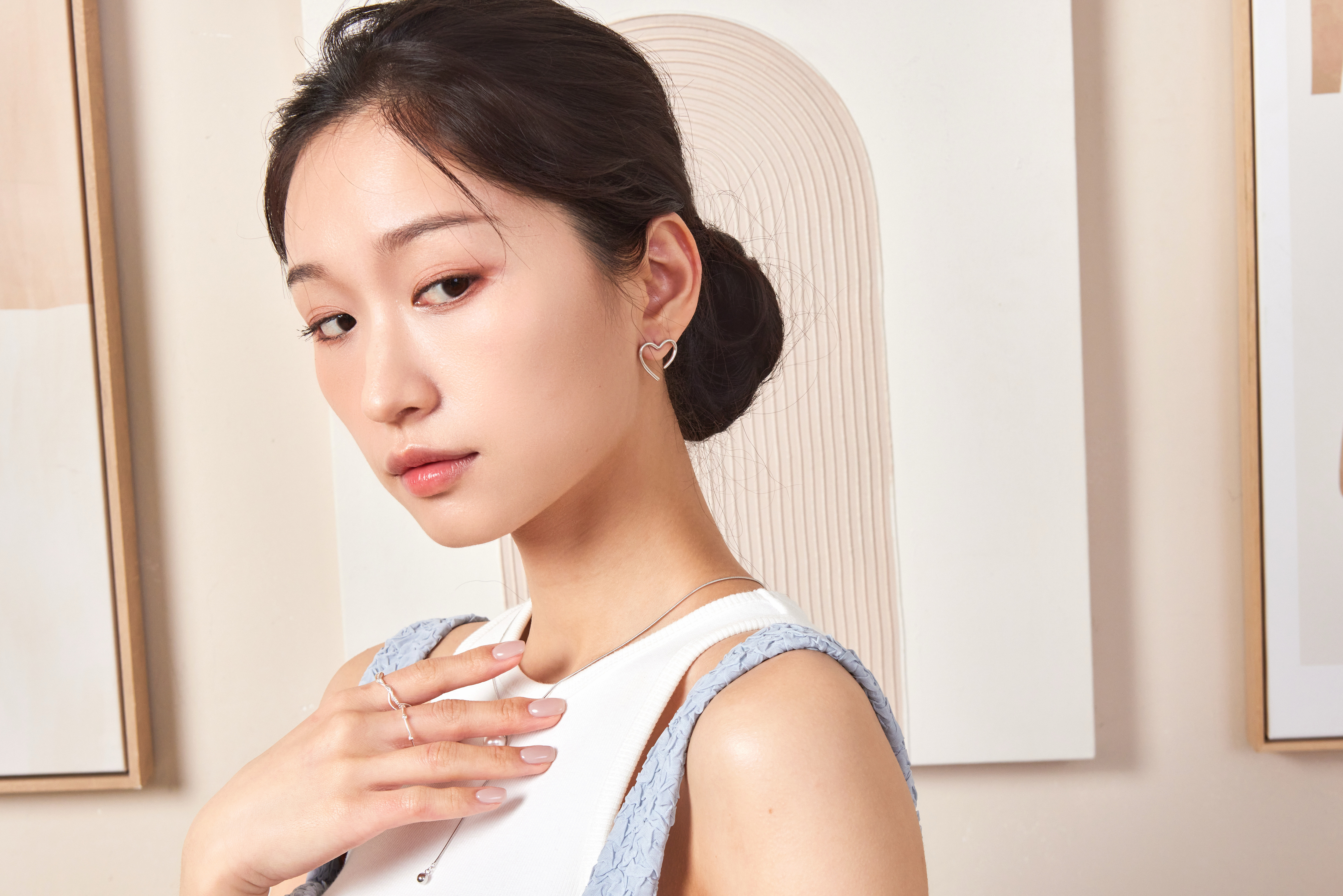 模特輕側頭部，純銀愛心耳環在髮絲間若隱若現，突顯溫柔氛圍