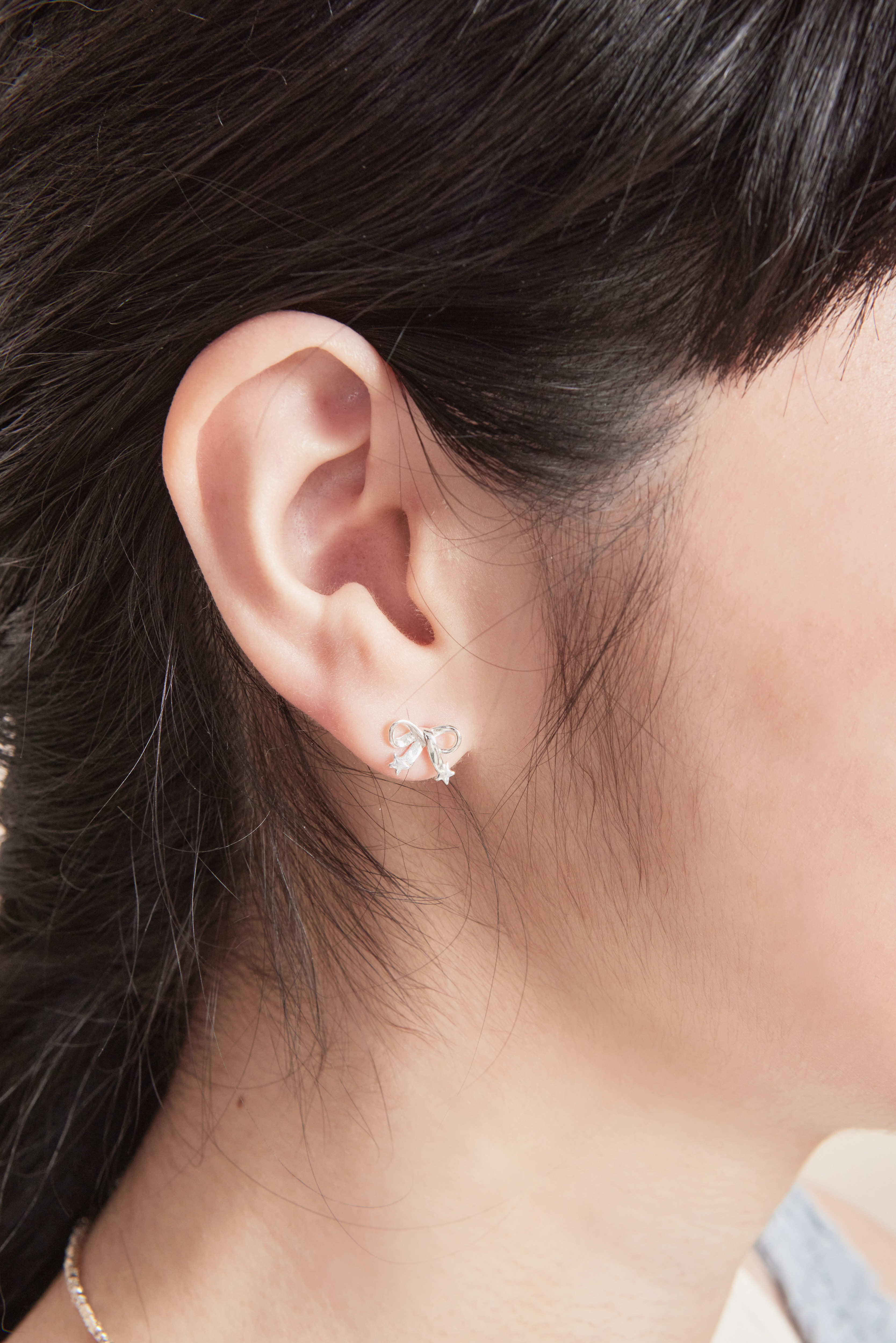 模特近距離配戴純銀蝴蝶結耳環特寫，細緻耳飾與自然妝容相互襯托