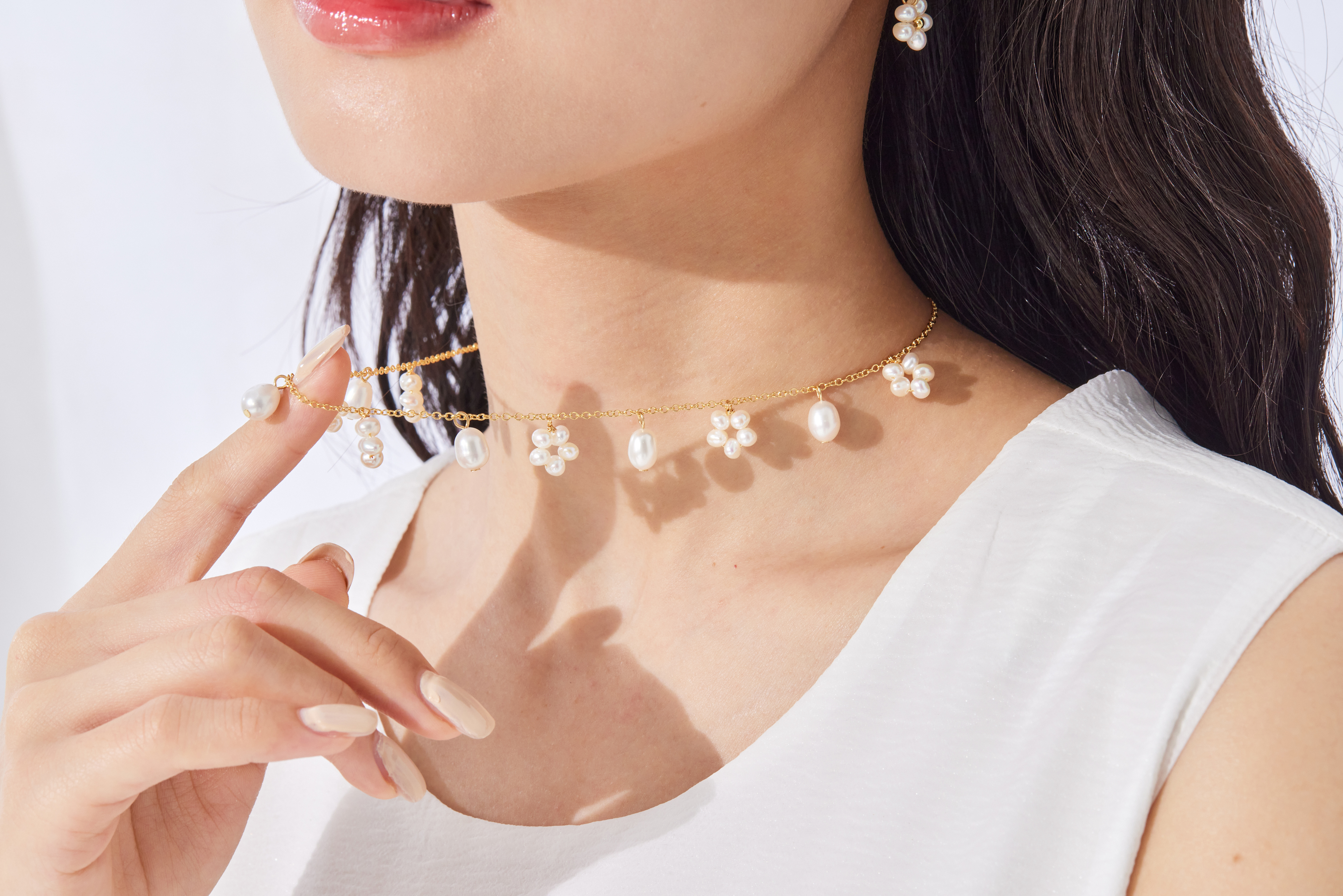 模特脖頸項鍊細節特寫，珍珠與金色鍊身交織