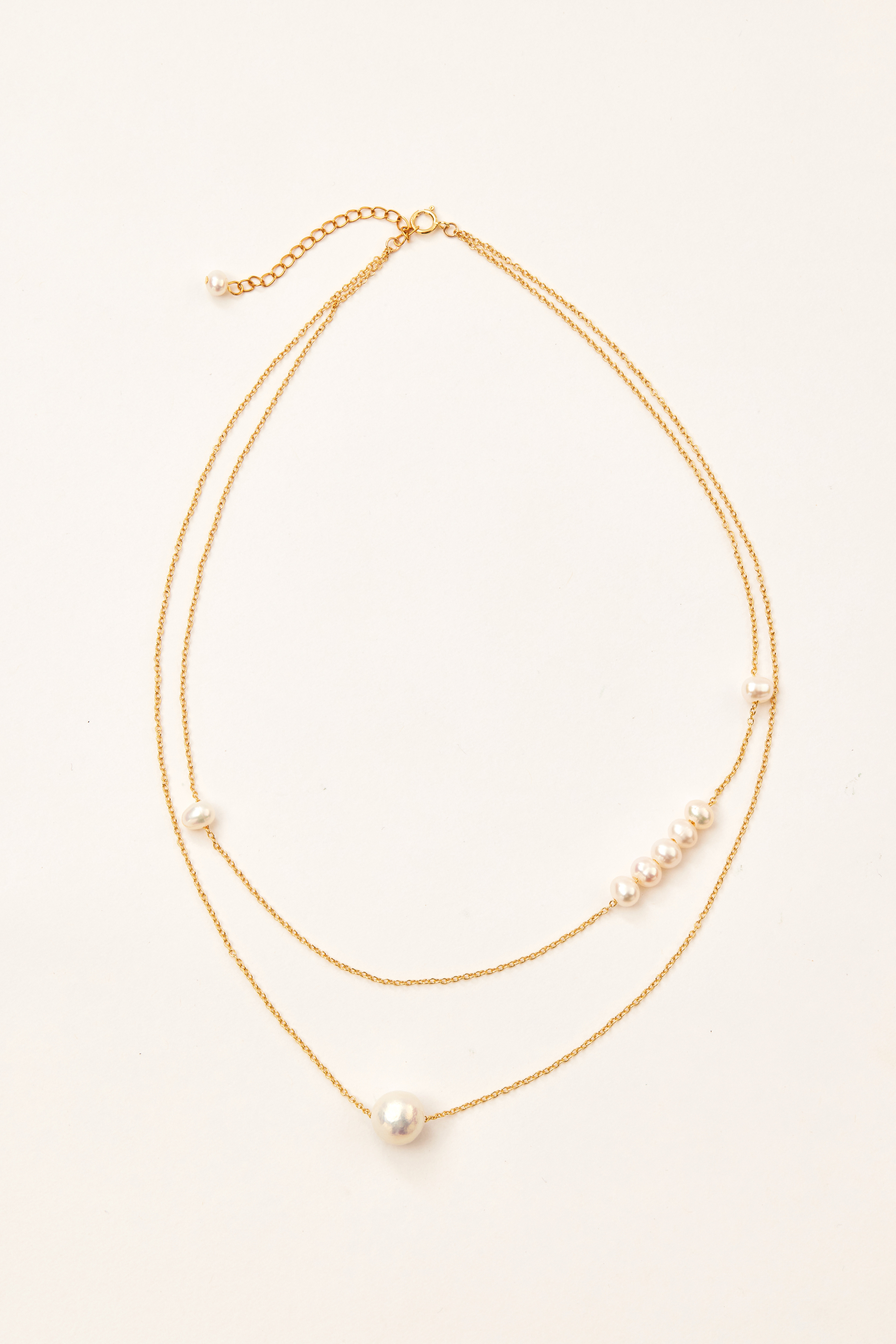 項鍊與布面背景拍攝，營造柔和光影與金屬溫潤質感