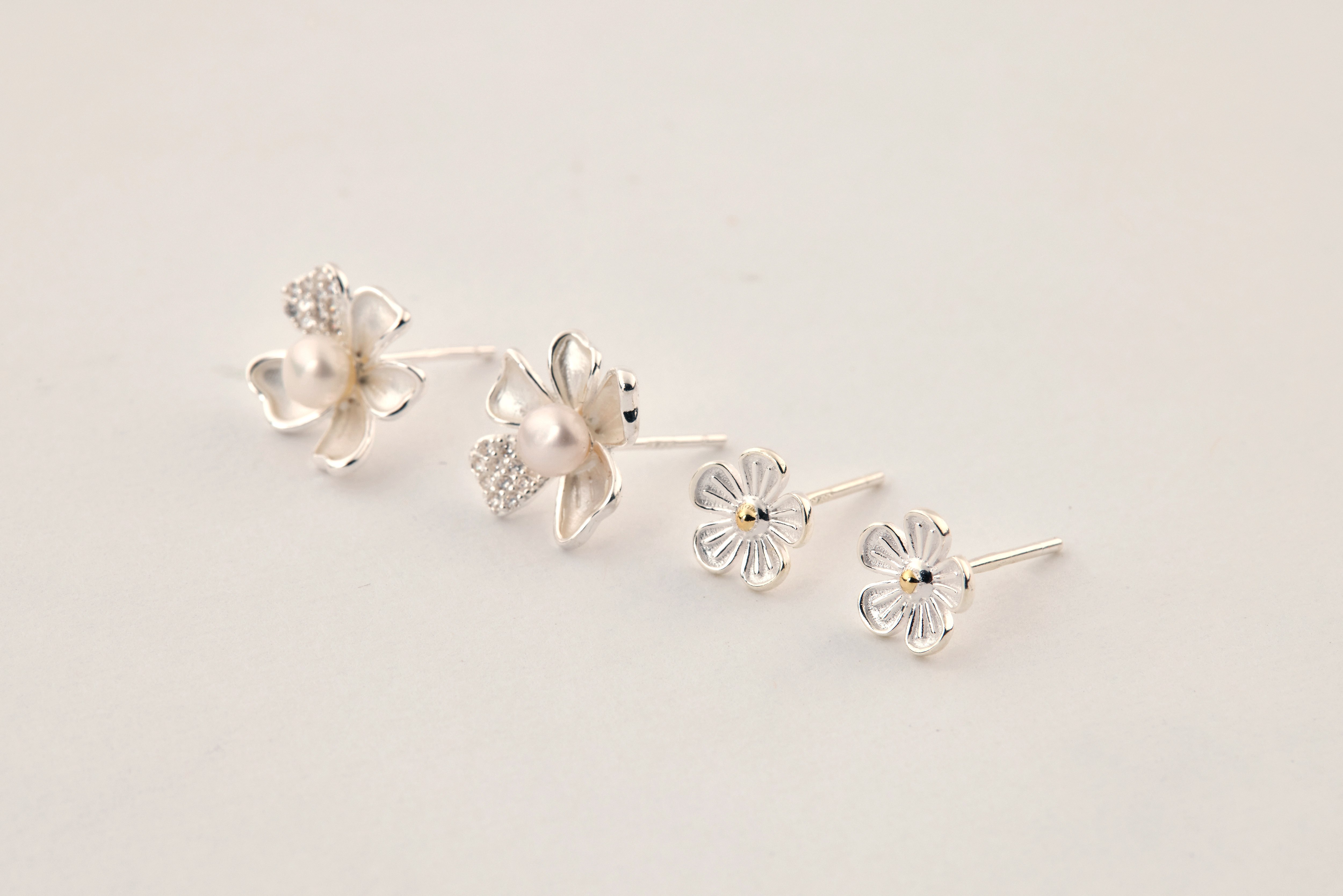 純銀小花耳環與其他純銀耳飾一同平拍，展現整體搭配感