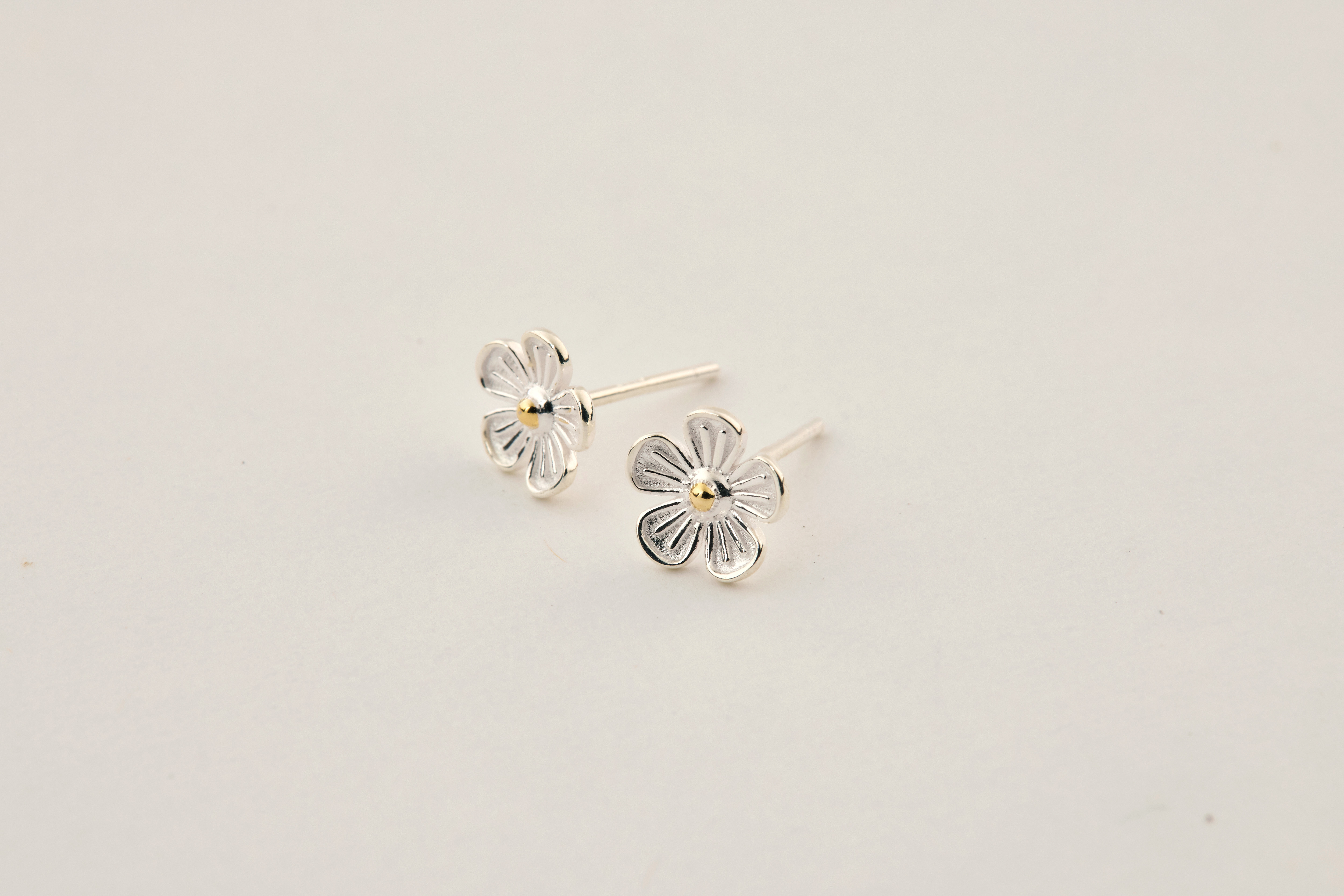 單獨一對耳環擺放於柔和背景，營造質感氛圍