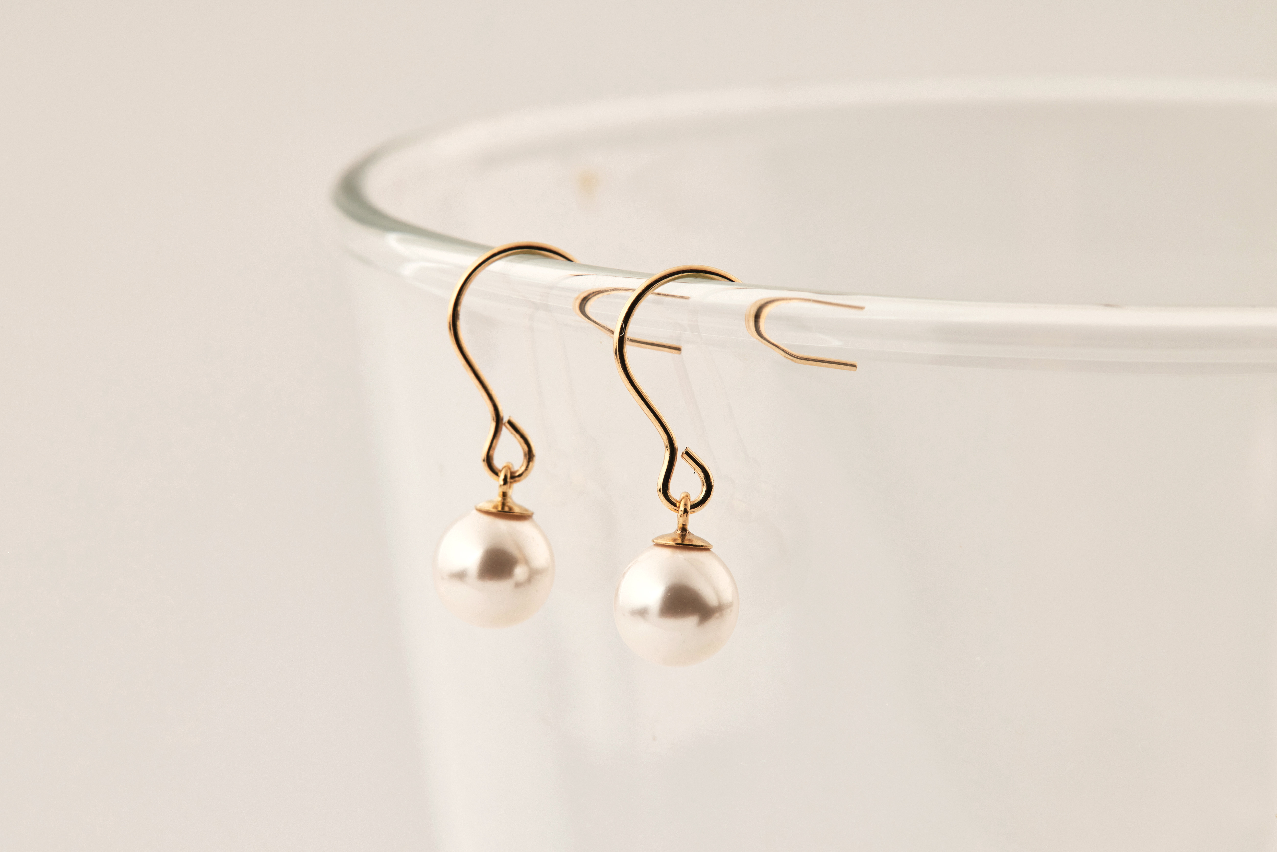 人工珍珠耳環近拍照，突顯圓潤光澤與金屬質感