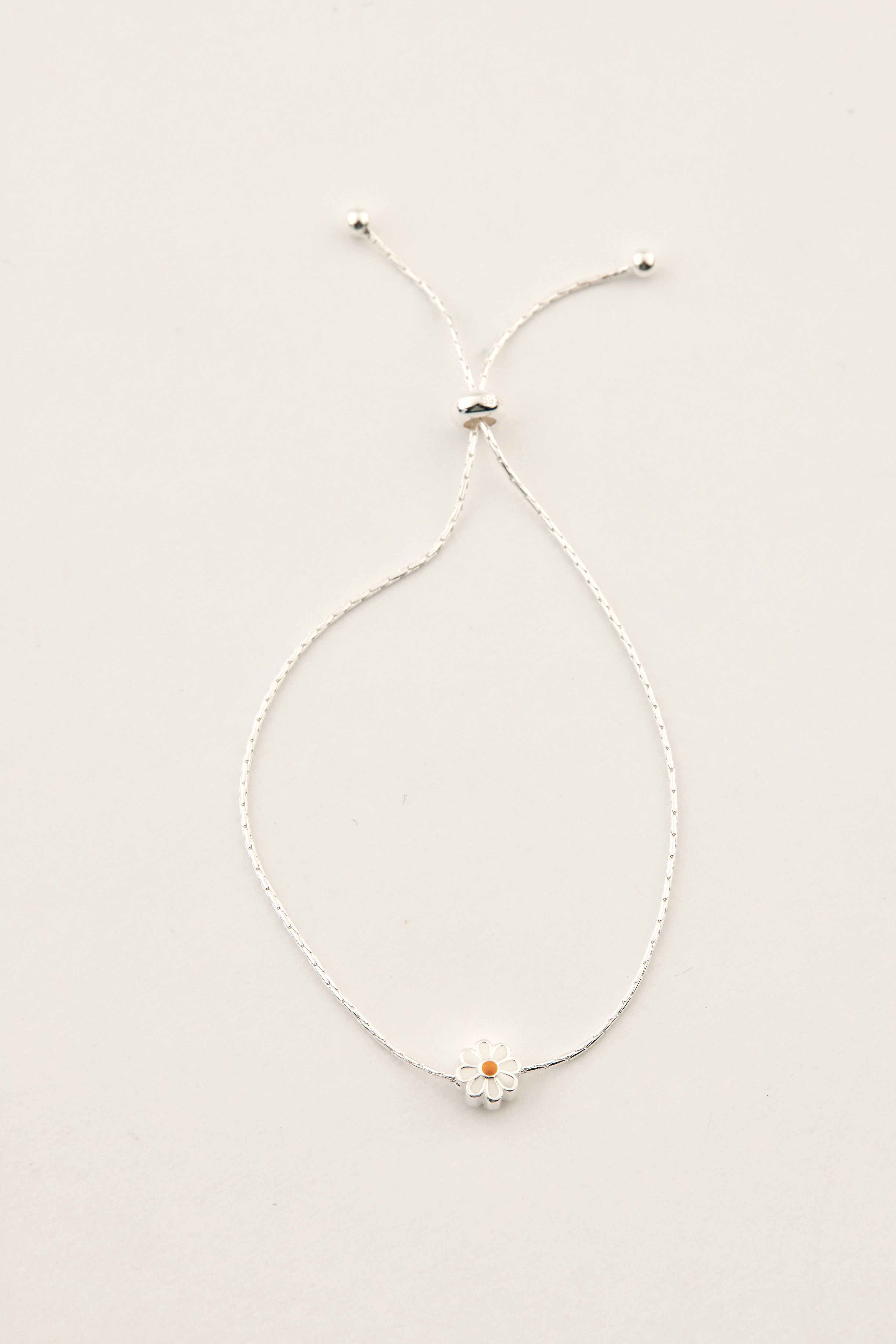 手鍊擺放於素色背景，展現清晰的純銀質地