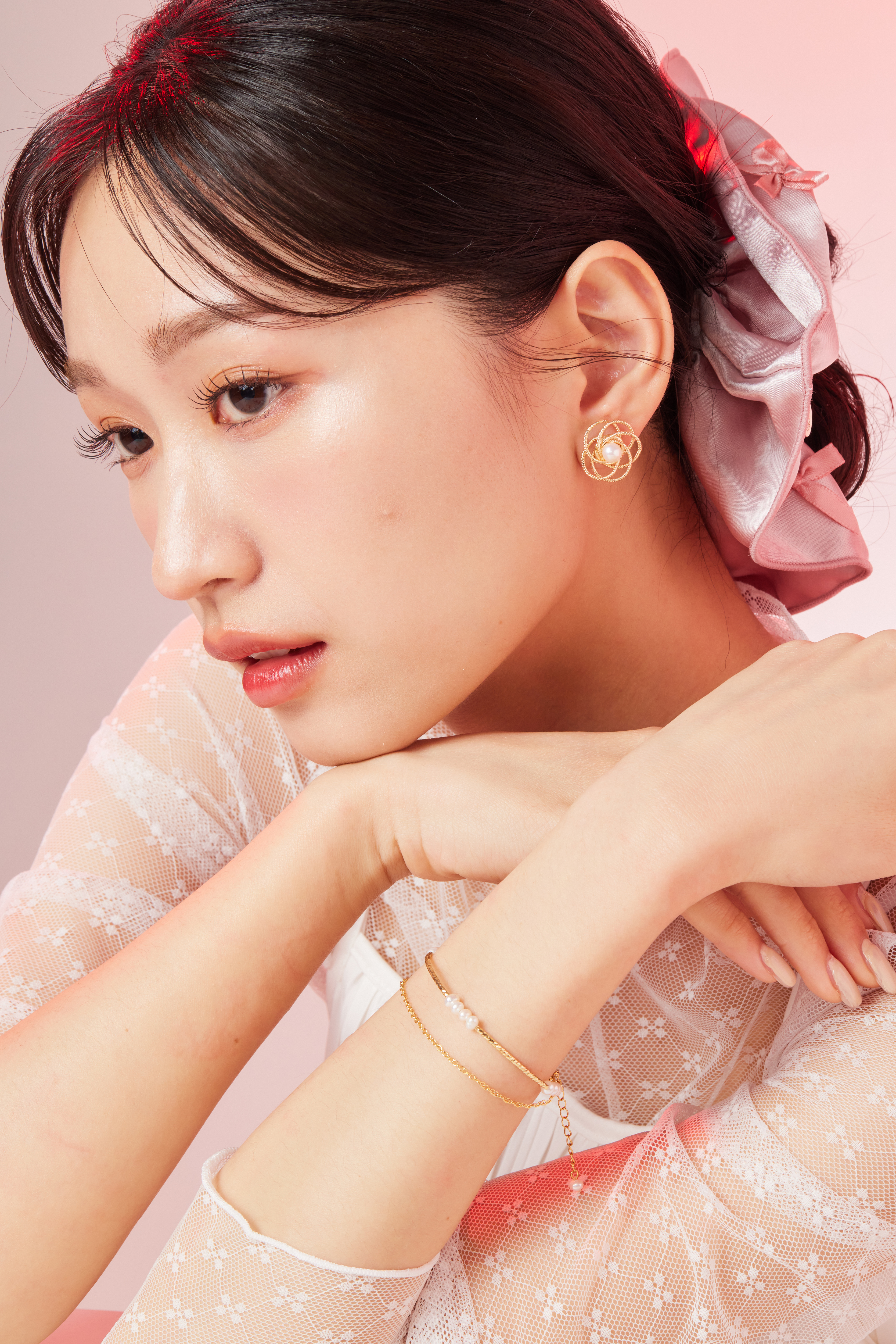 模特近拍佩戴照，珍珠與金鍊在手腕上閃耀柔和光澤