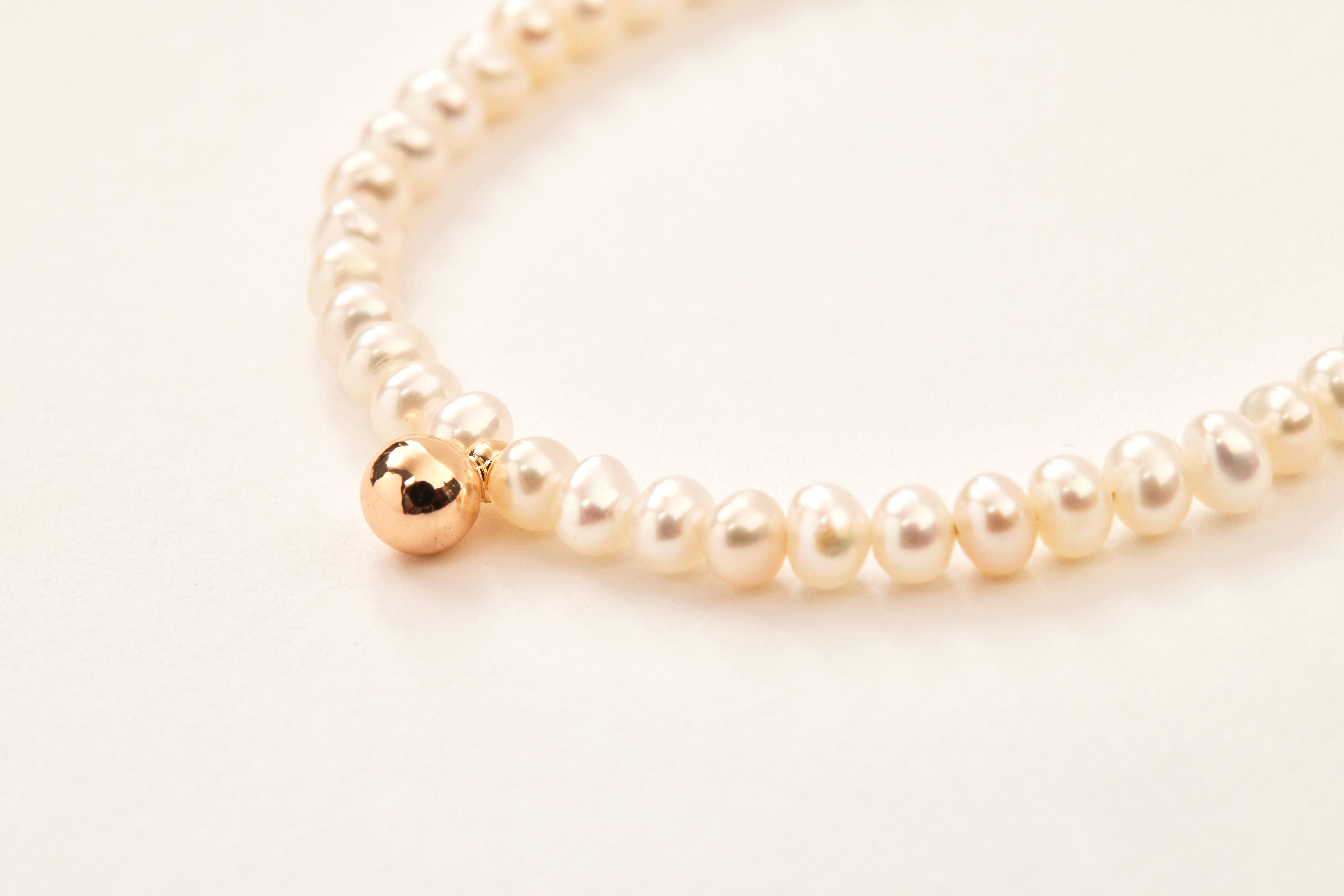 金球與珍珠細節特寫，展現金屬與天然材質交織的質感