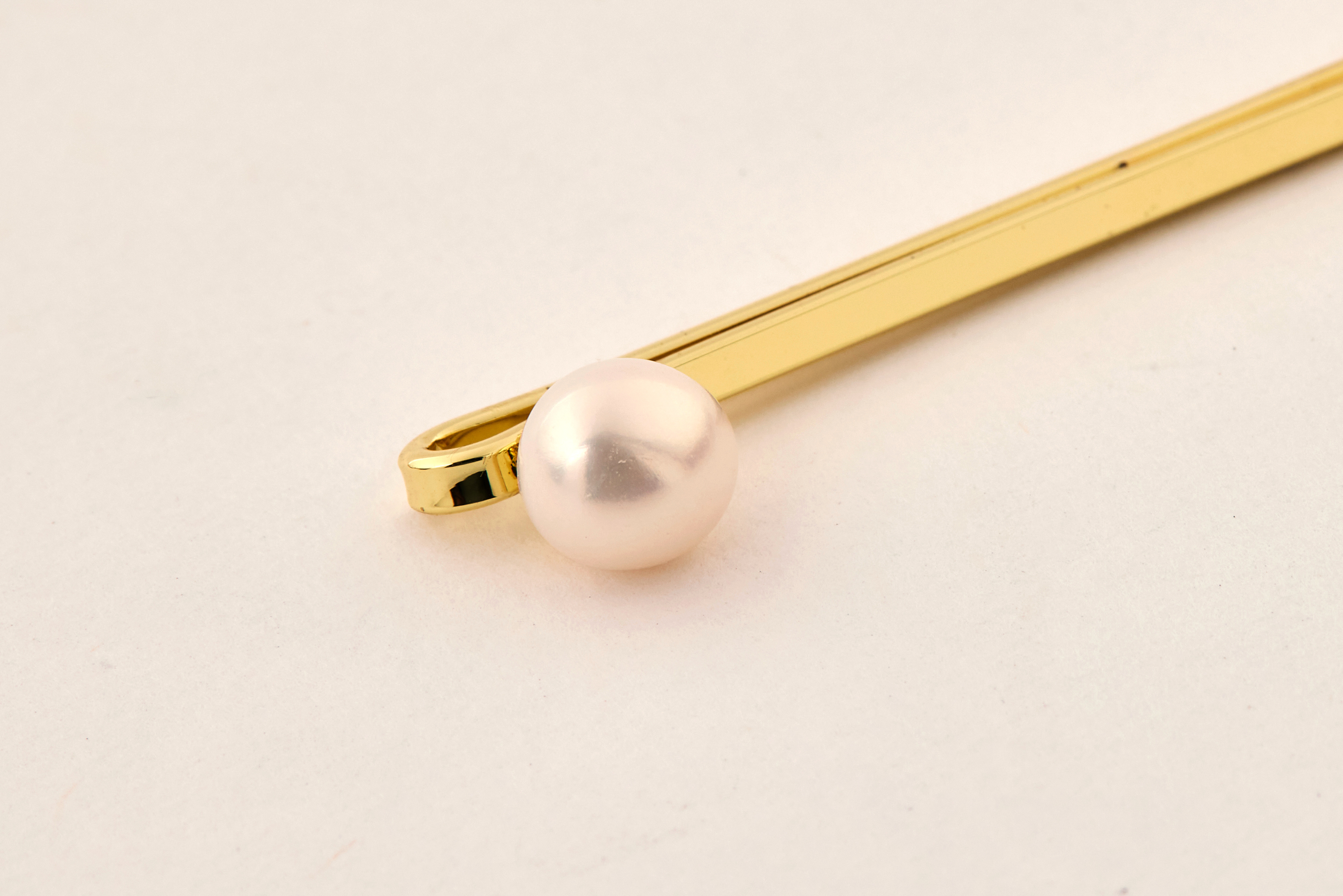 白色珍珠髮夾平拍氛圍照，融合柔和背景凸顯溫柔質感